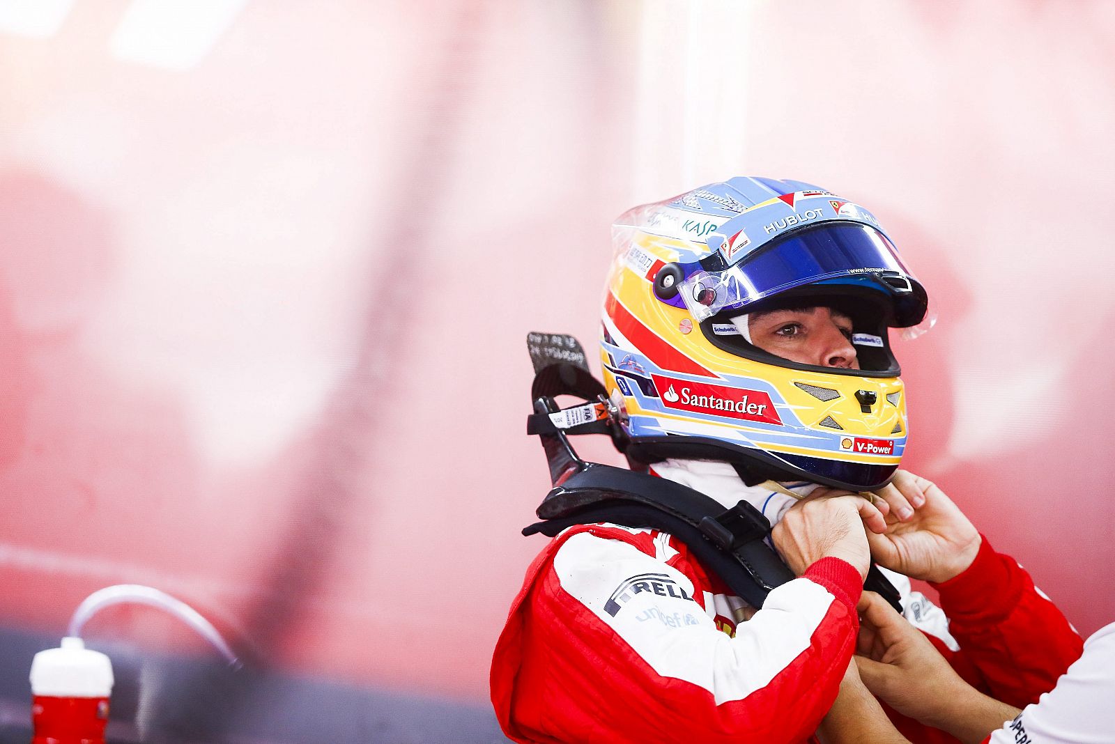 El piloto español de Fórmula Uno Fernando Alonso (Ferrari) se coloca el casco en el garaje de su escudería.