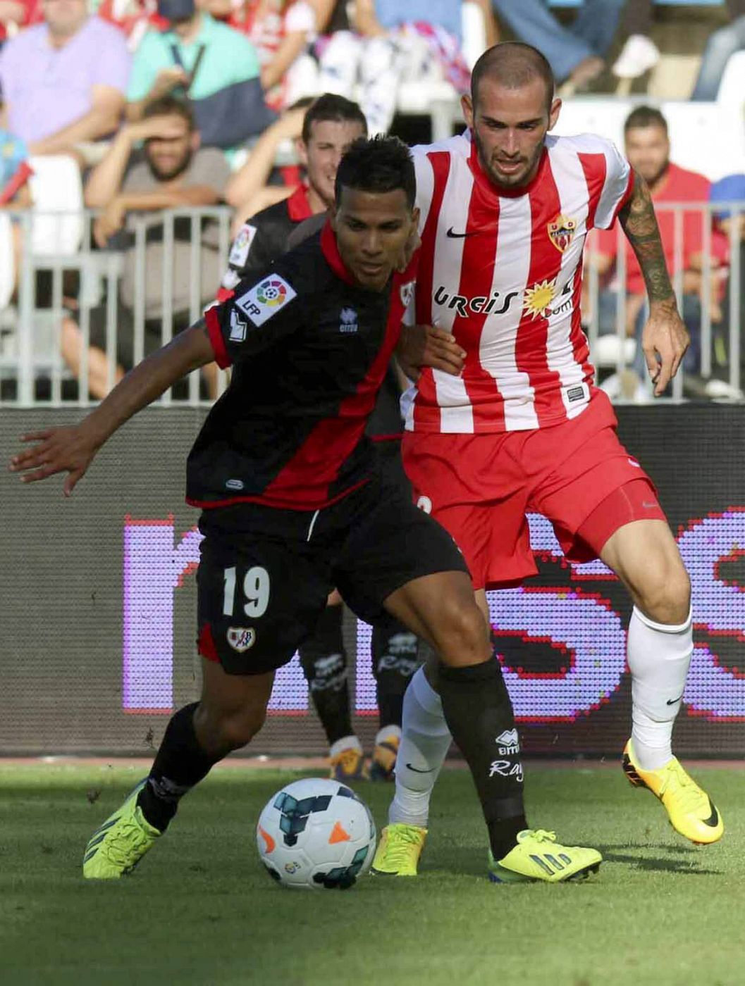 El delantero del Almería Aleix Vidal (d) disputa el balón con el centrocampista del Rayo Vallecano Jonathan Viera (i)