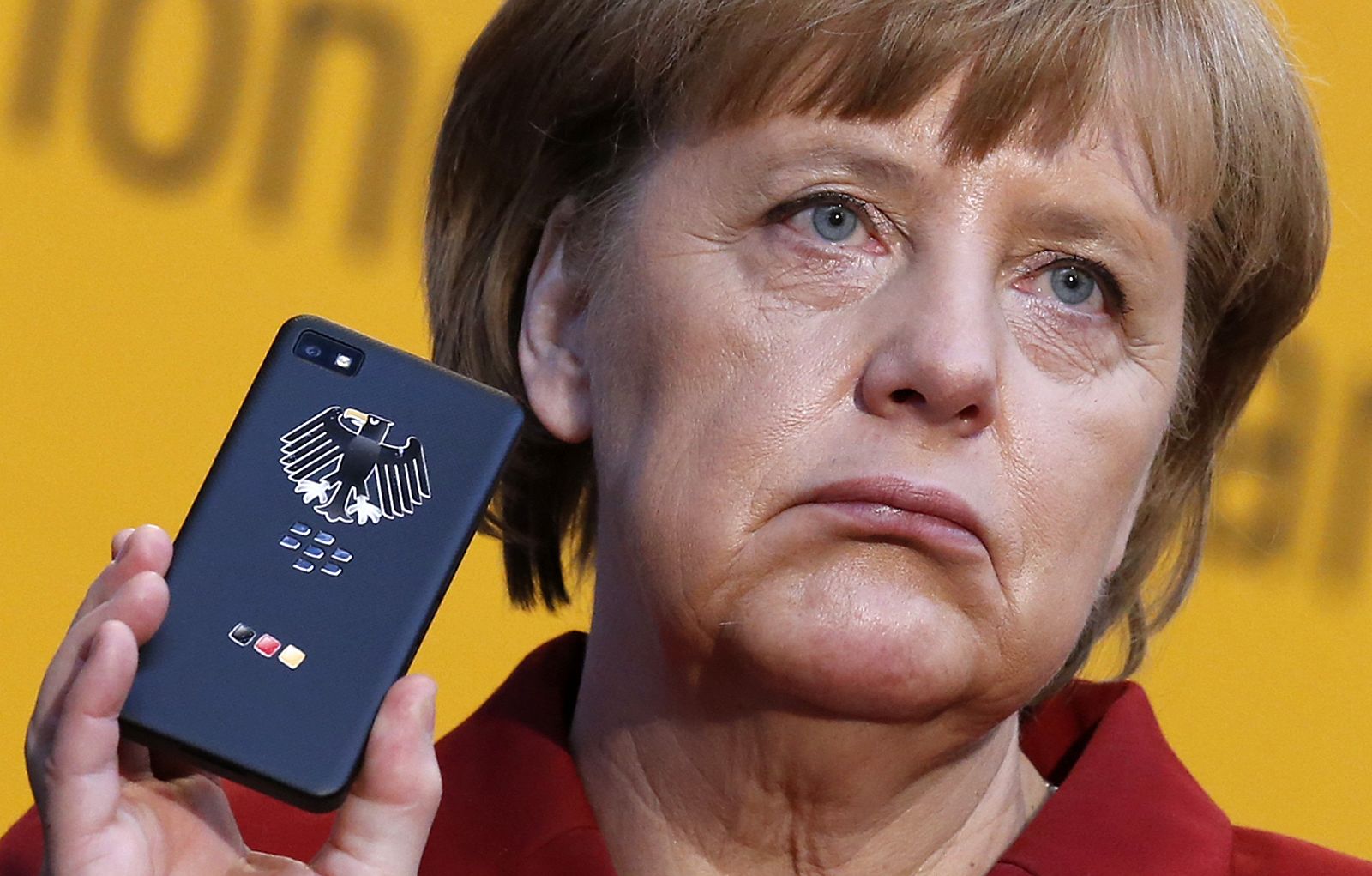 Angela Merkel muestra un móvil del Gobierno en la feria de informática de Hanover, en marzo de 2013
