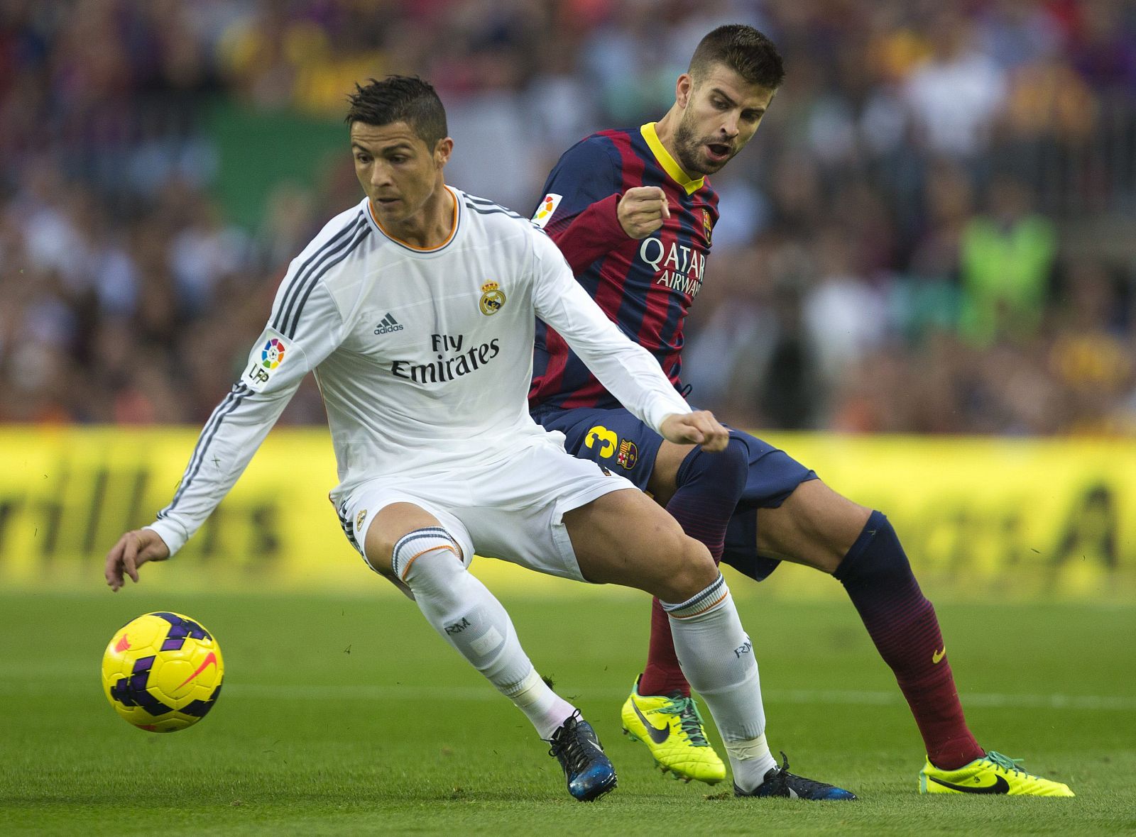 El delantero portugués del Real Madrid Cristiano Ronaldo lucha un balón con el defensa del F.C. Barcelona Gerard Piqué.