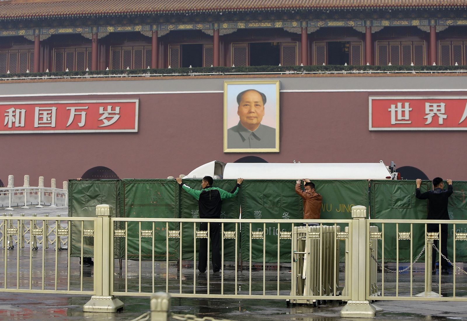 Policías colocan barreras para impedir la visión en el lugar en el que se ha estrellado un vehículo en la plaza Tiananmen de Pekín