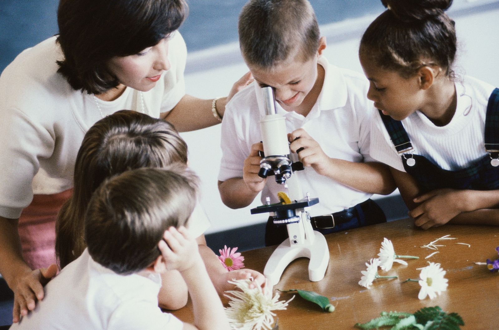 Niños mirando con un microscopio.