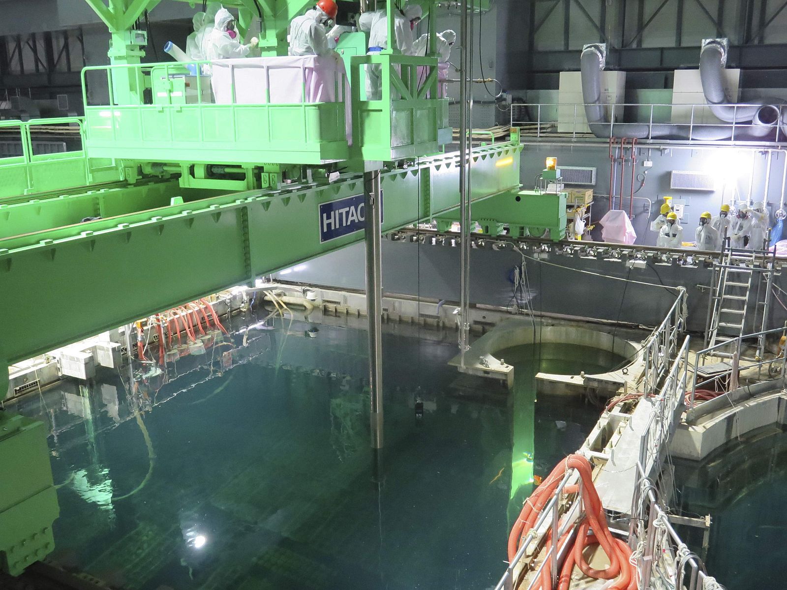 Técnicos de Tepco llevan a cabo la operación para extraer las barras de combustible nuclear de la piscina del reactor 4 de Fukushima