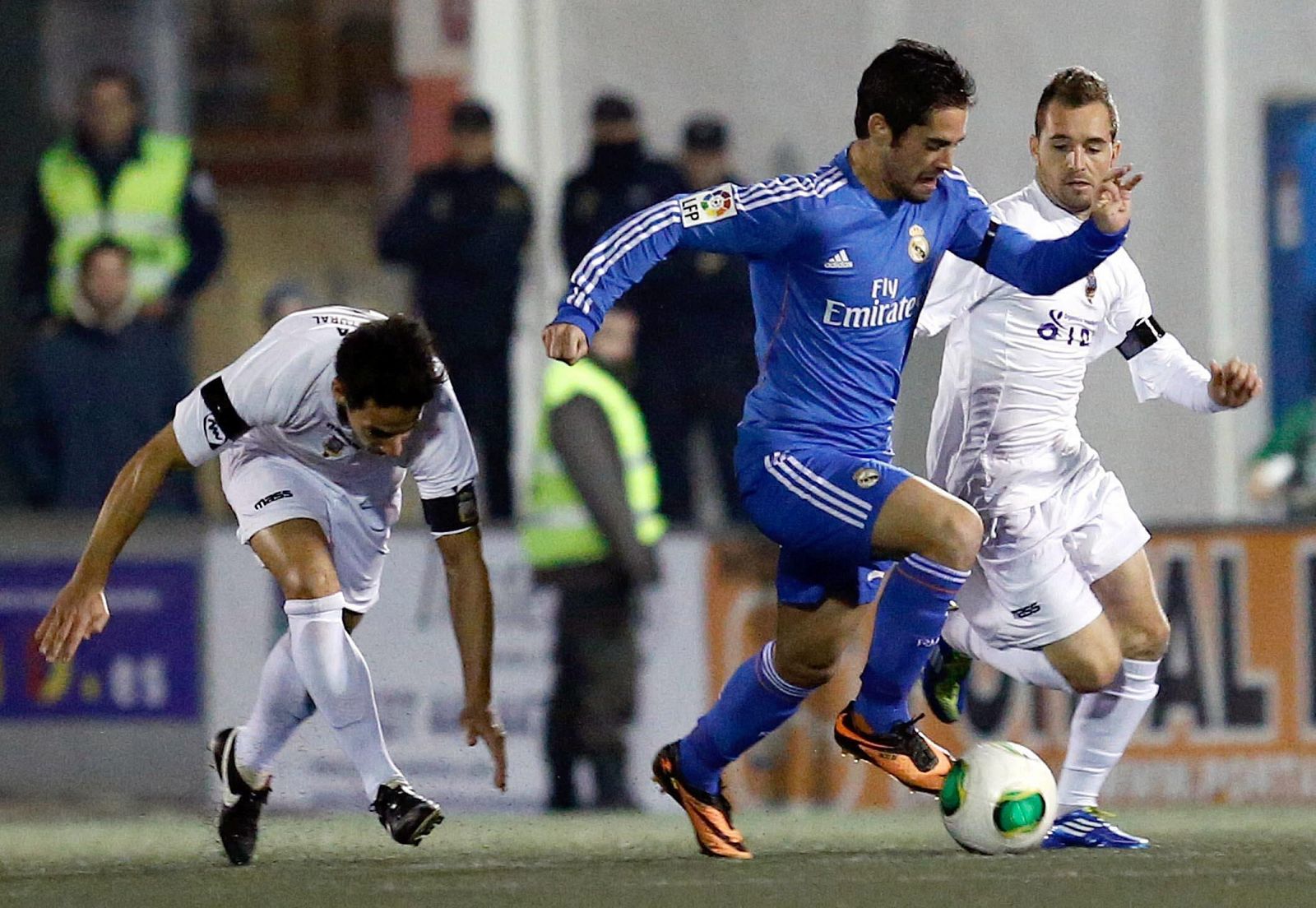 El centrocampista del Real Madrid, Francisco Alarcón "Isco" (c), conduce el balón ante los jugadores del Olimpic de Xátiva