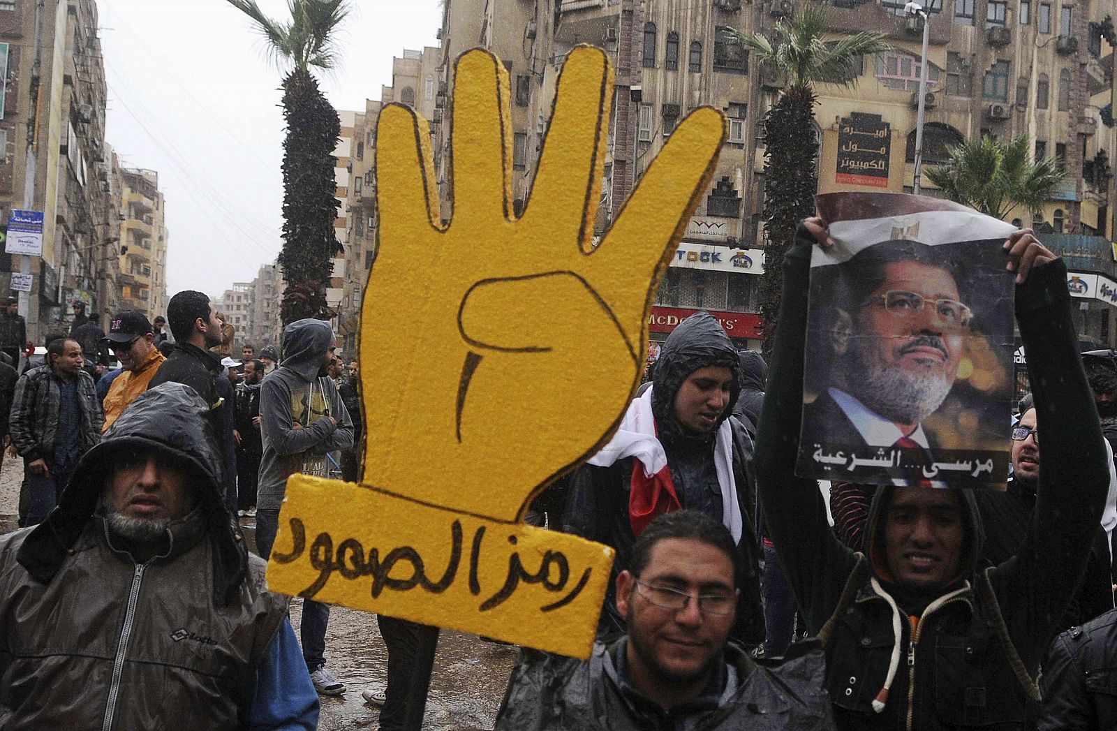 Supporters of the Muslim Brotherhood and ousted Egyptian President Mursi, raise a placard with a "Rabaa" sign that reads "Symbol of steadfastness" during a protest in Al-Haram street, in Cairo