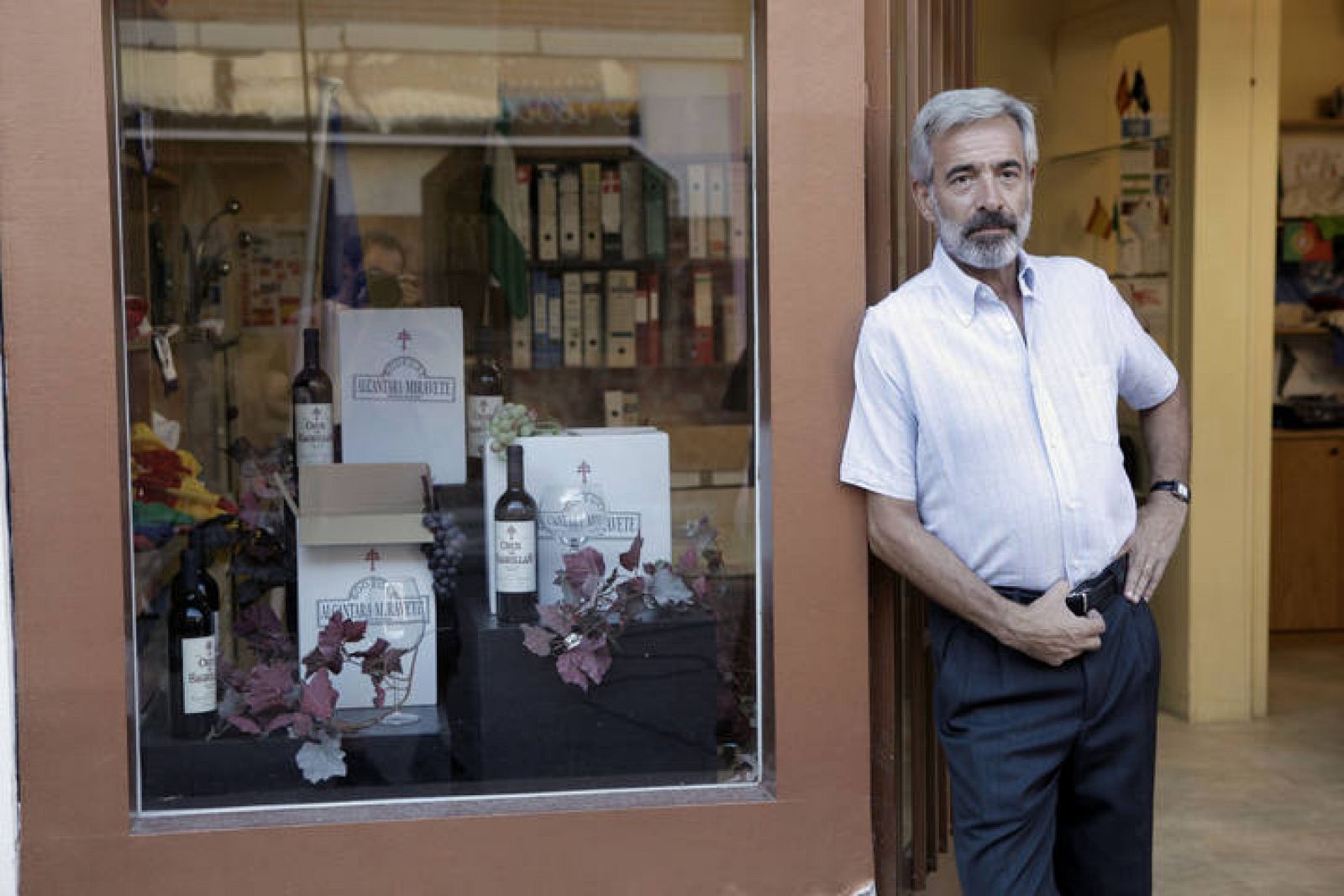 Imanol Arias da vida a Antonio Alcántara, que posa ante su tienda de estandartes y banderas.