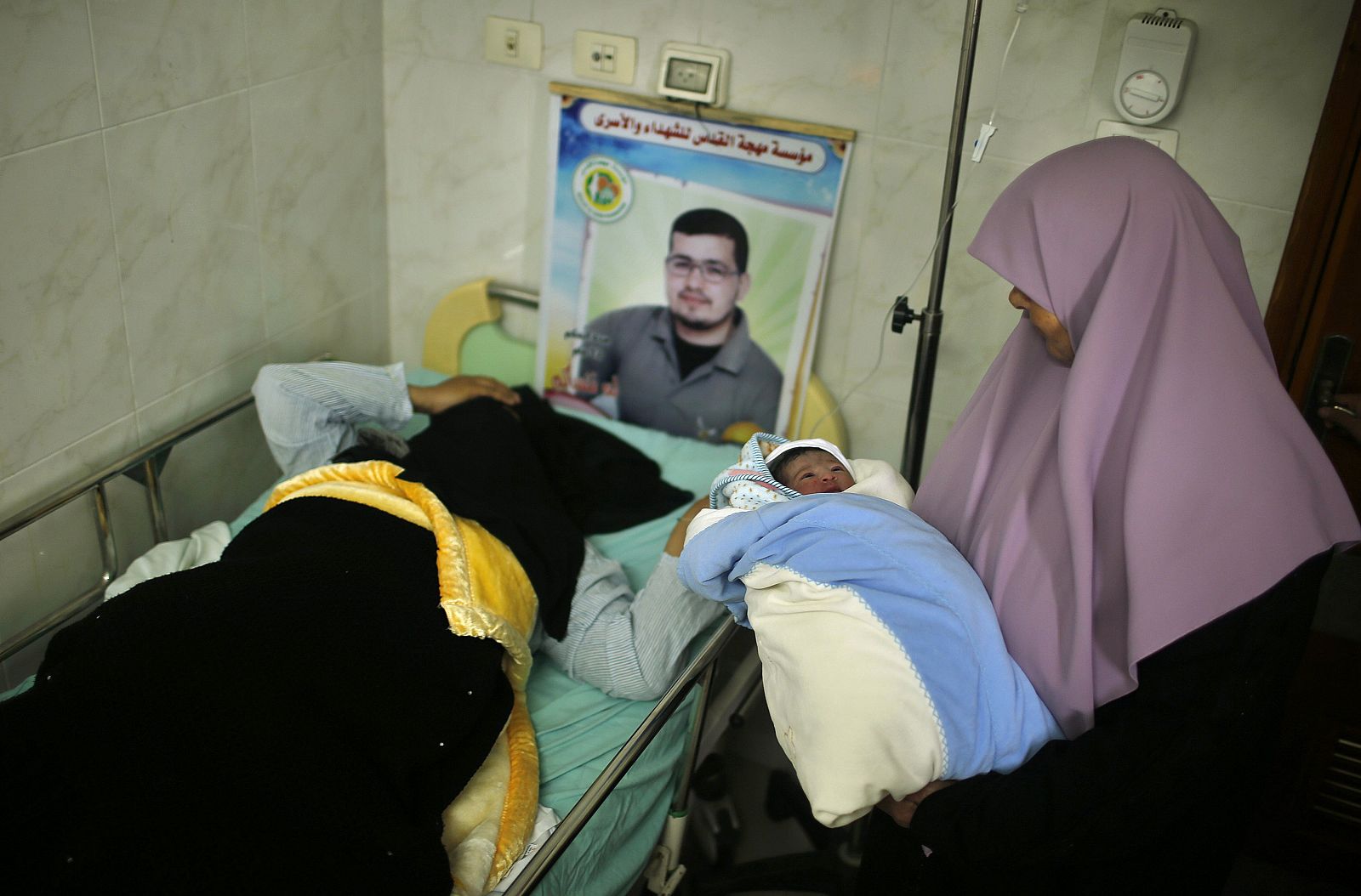 Hana descansa en el hospital con su bebé y con el recuerdo de su marido, preso en una cárcel israelí, en un póster en la pared.