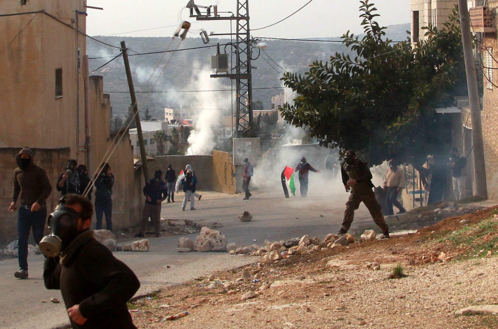 Un grupo de palestinos lanza piedras hacia las fuerzas de seguridad israelíes este viernes en protesta contra la política de expropiaciones o colonización de ese Estado.