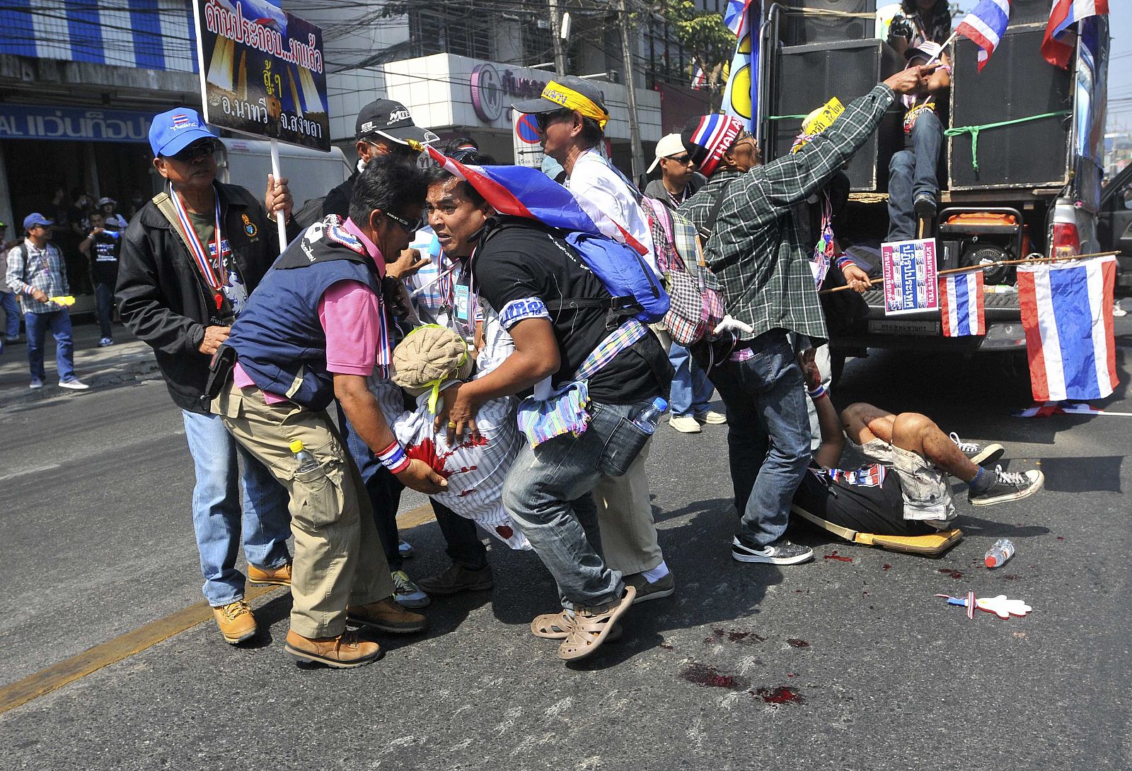 Manifestantes antigubernamentales ayudan a los heridos en la explosión que ha tenido lugar en una marcha en Bangkok, Tailandia