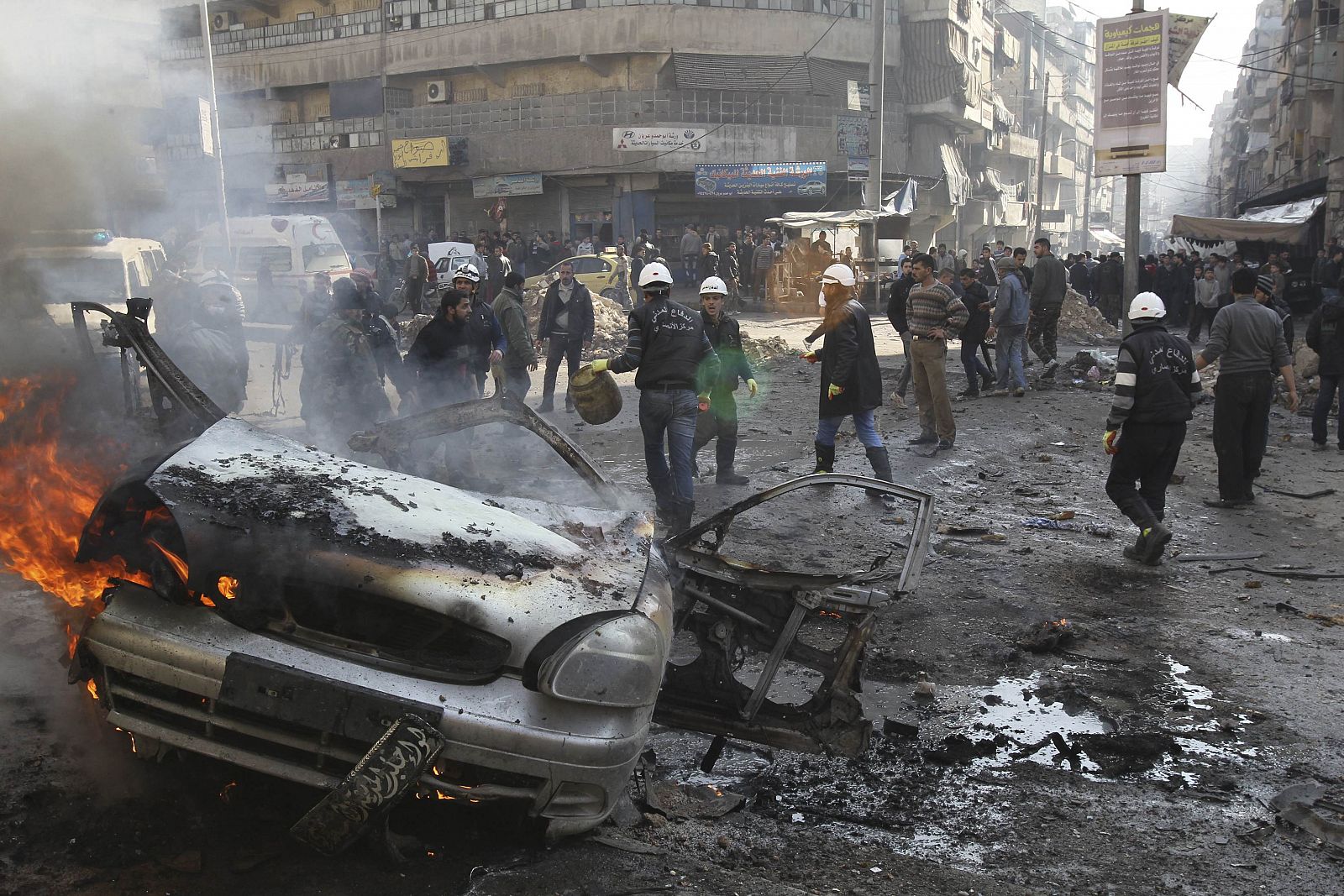 A car burns amid damage caused by what activists said was an air strike by forces loyal to Syria's President Assad in Aleppo
