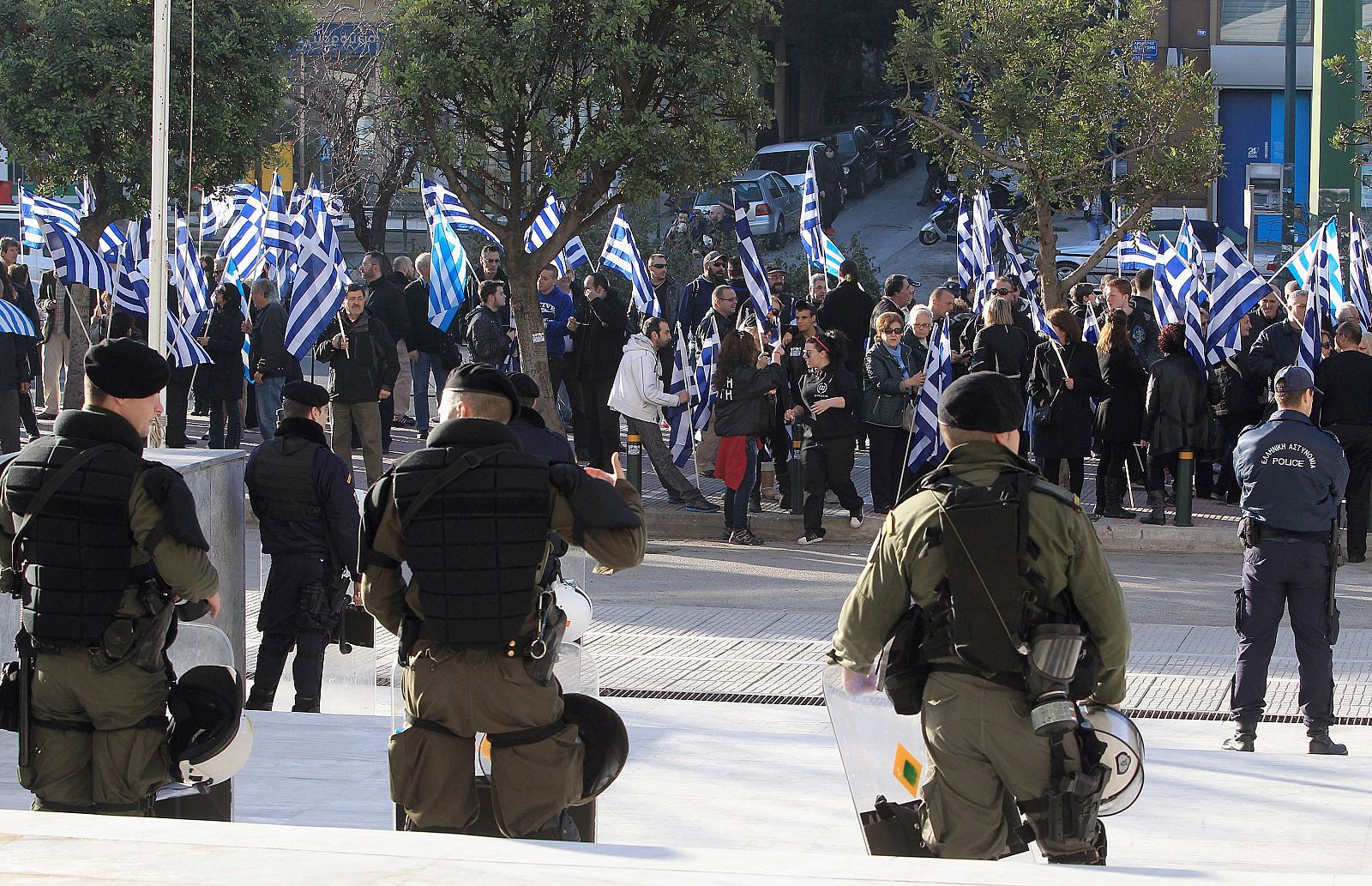 Policías y militares griegos vigilan a unos manifestantes en Atenas