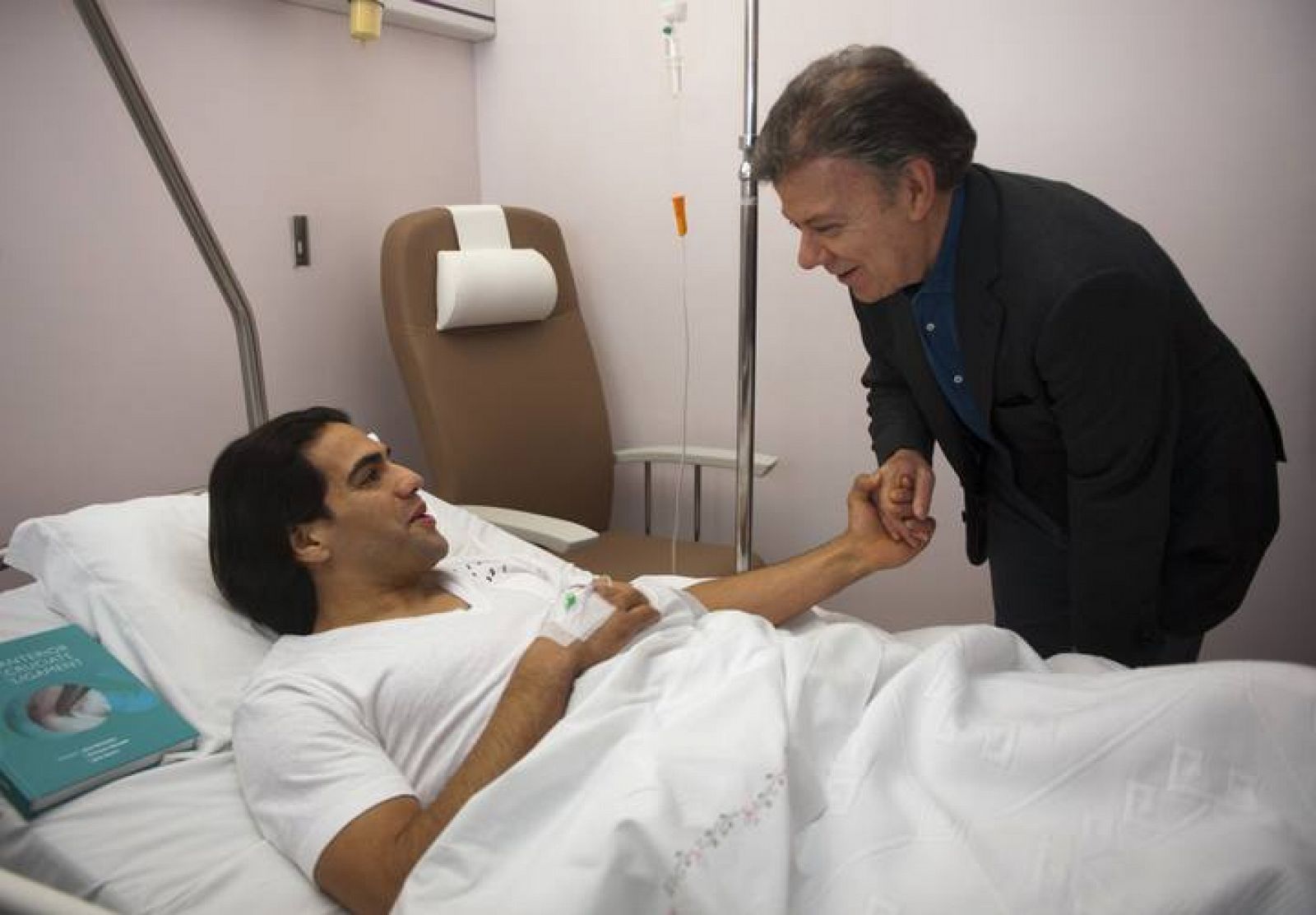 El presidente de Colombia, Juan Manuel Santos, saluda a un convaleciente Radamel Falcao