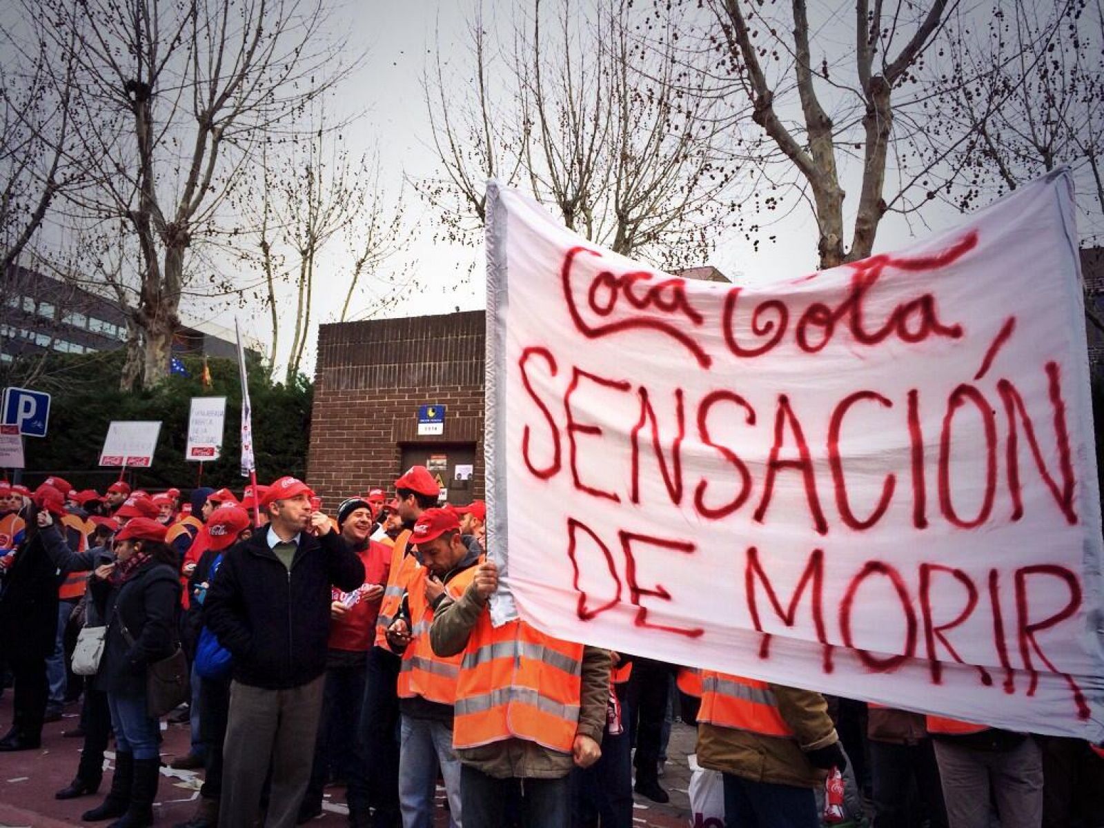 Un grupo de trabajadores enarbola una pancarta que reza "Coca-Cola, sensación de morir".