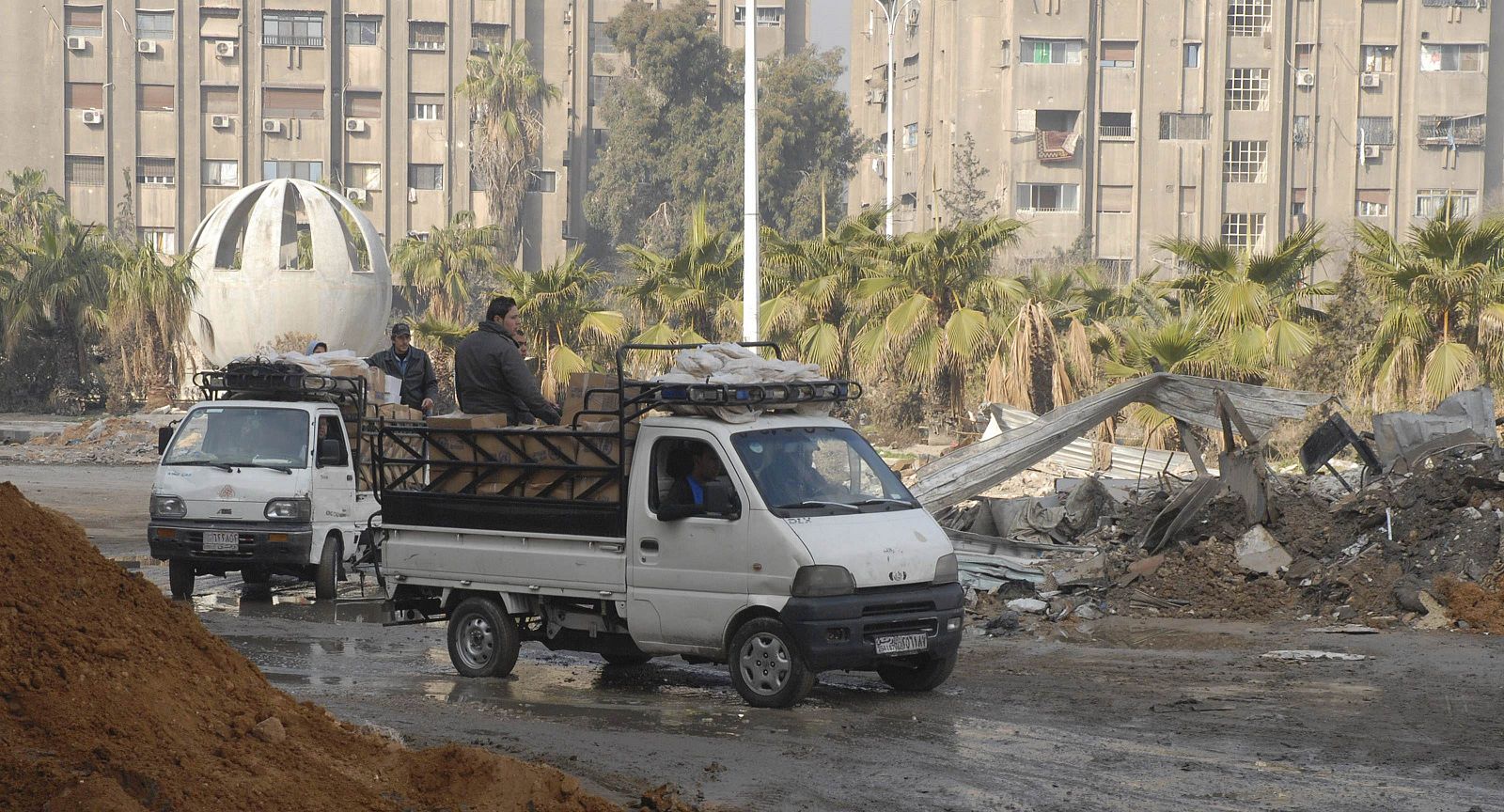 Trucks carrying food aid make their way to the besieged al-Yarmouk camp, south of Damascus