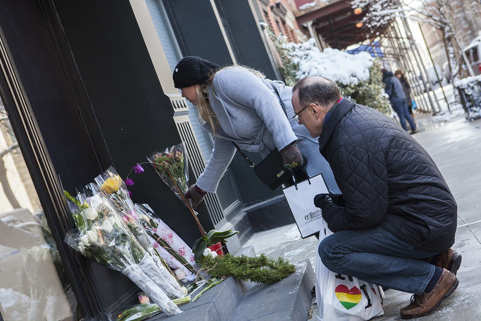 Passersby leave flowers on a makeshift memorial for actor Philip Seymour Hoffman in front of his apartment building in the Manhattan borough of New York