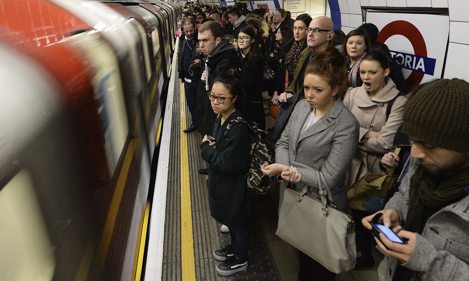 Viajeros se disponen a subir a bordo de un metro en la estación de Victoria en Londres (Reino Unido)