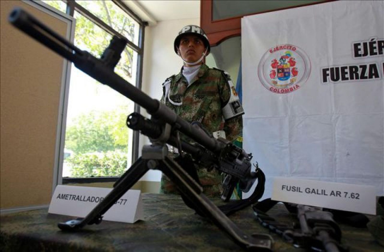 Un miembro del Ejército de Colombia, custodia unas armas incautadas a las FARC
