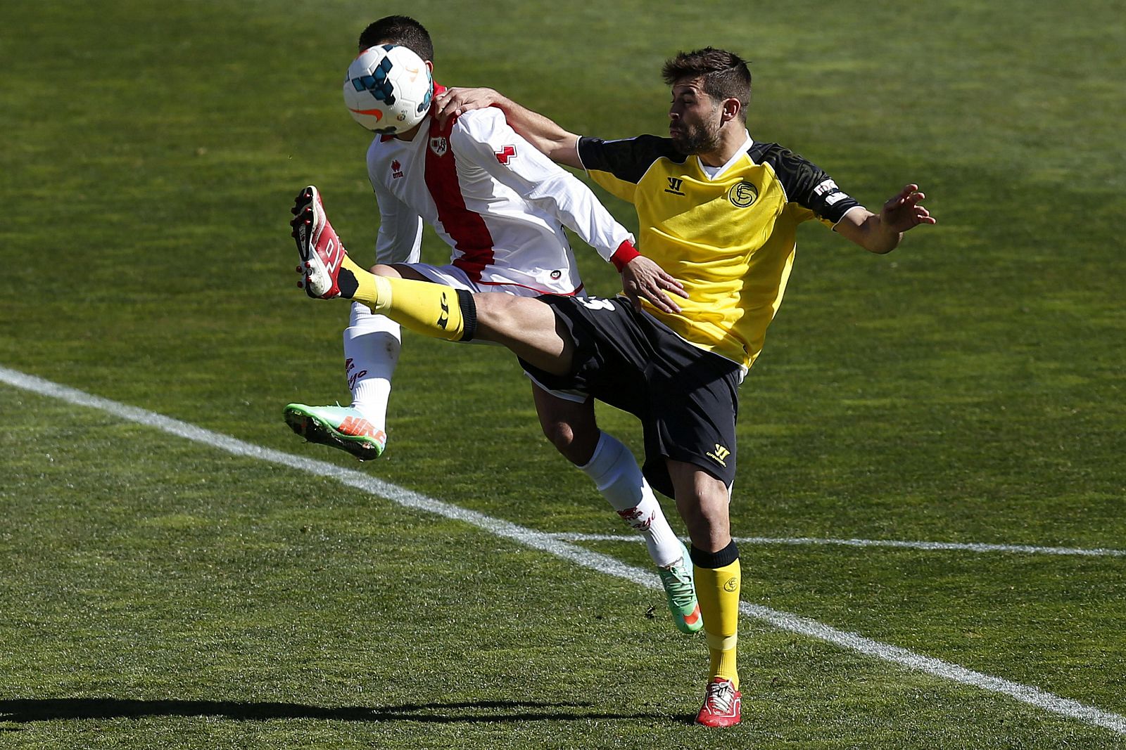 Yago Falqué (i), se lleva la pelota ante el defensa argentino del Sevilla, Jorge Andújar Moreno "Coke" (d).