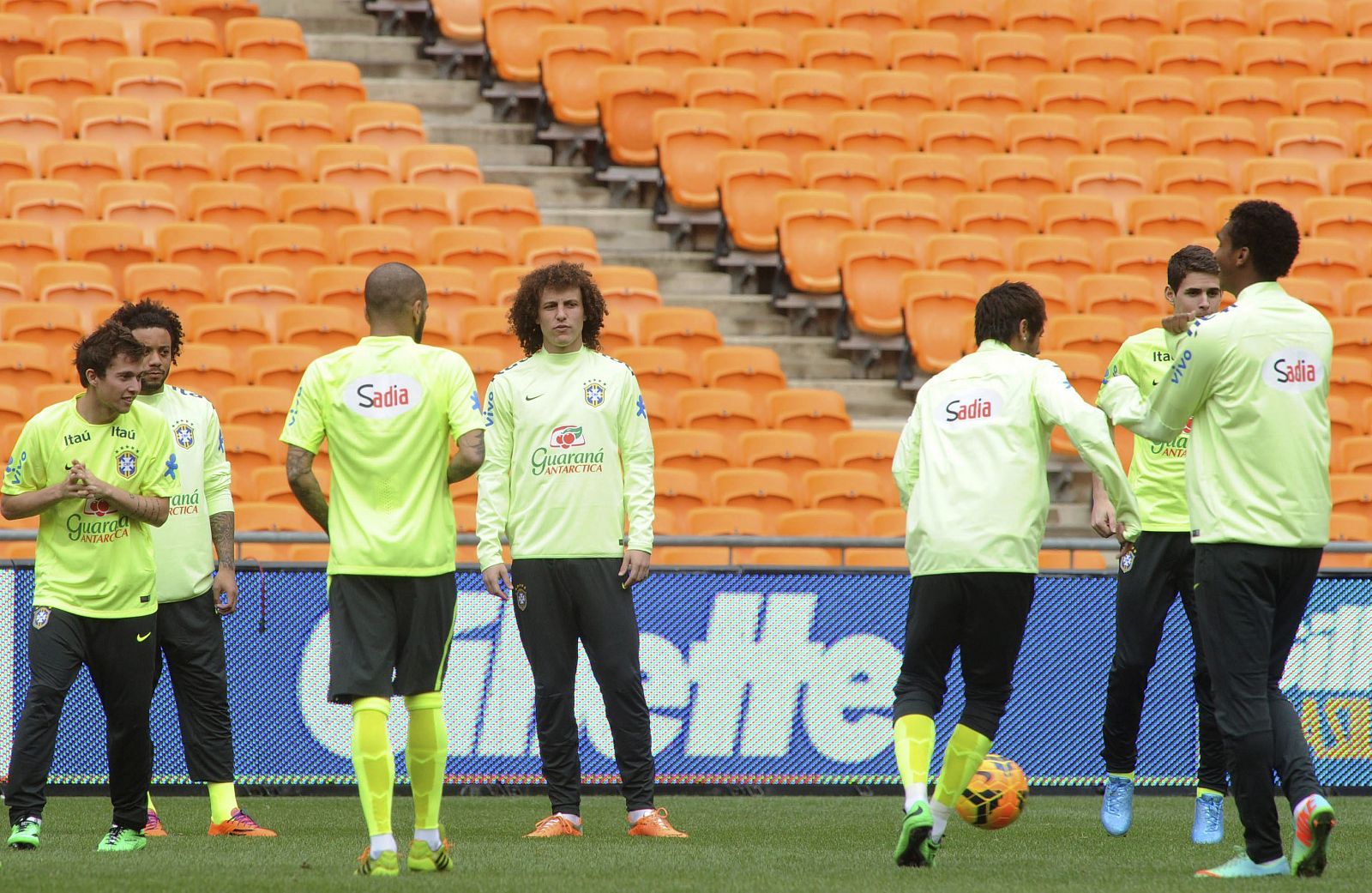 Los jugadores de la selección brasileña de fútbol calientan durante el entrenamiento del equipo en el Soccer City