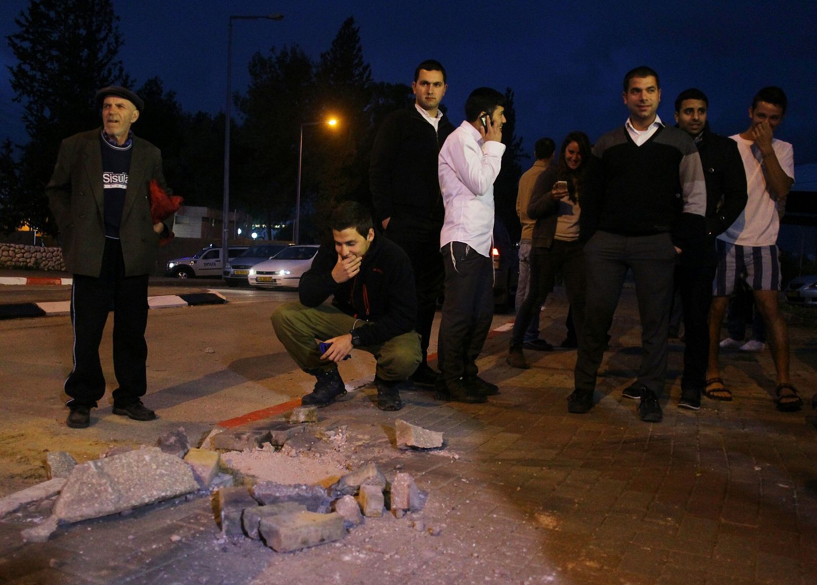 Un grupo de ciudadanos israelíes comprueban los daños causados por un cohete lanzado desde Gaza en la ciudad de Sderot.