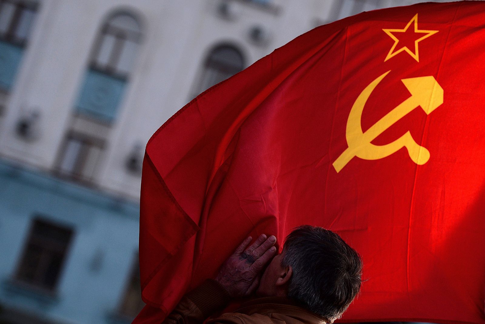 Un hombre besa la bandera de la URSS en Simferópol, capital de Crimea