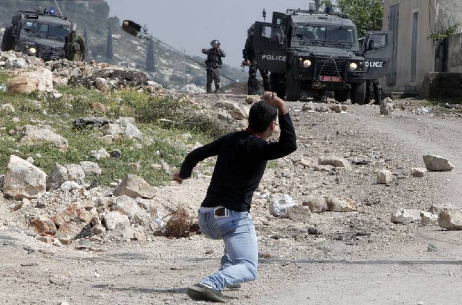 Un palestino arroja piedras contra soldados israelíes en Nablus, Cisjordania