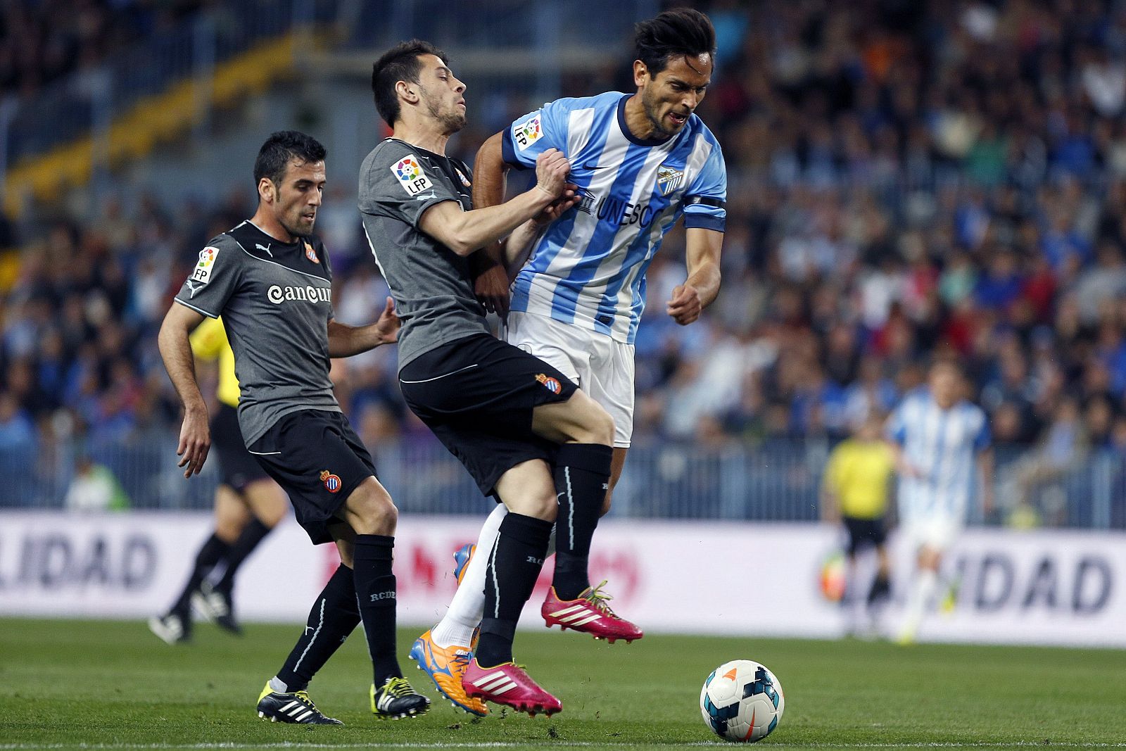 El delantero paraguayo del Málaga Roque Santa Cruz (d) lucha un balón con el delantero portugués del Espanyol Luis Miguel Alfonso