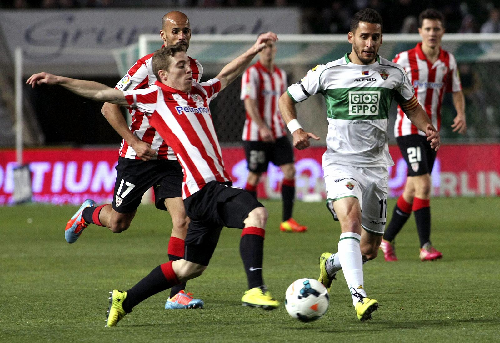 El jugador del Ath. de Bilbao, Iker Muniain (i), intenta controlar el balón ante centrocampista del Elche, Ferrán Corominas