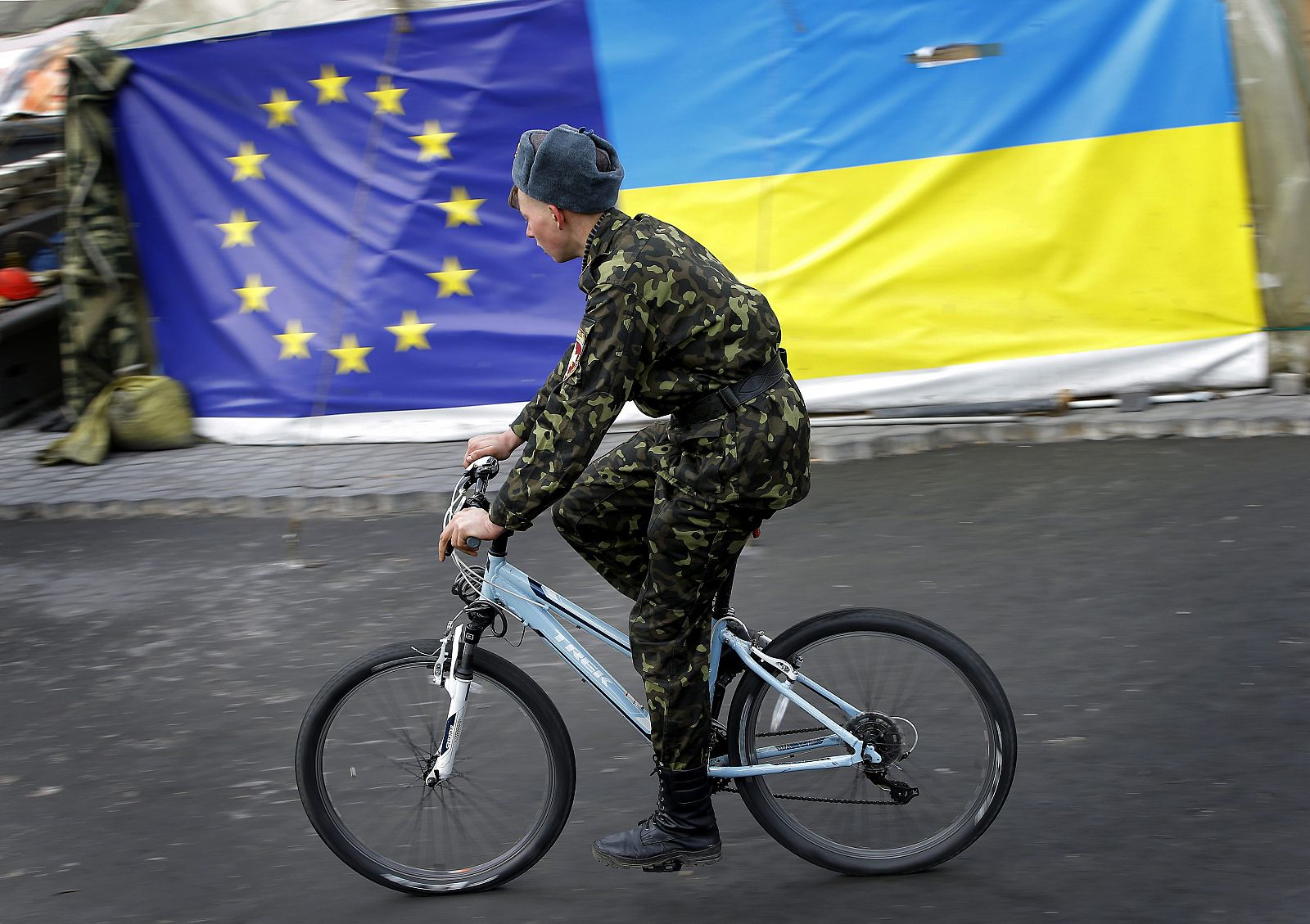 Un miembro de las autodenominadas "defensas" de maidán pasa junto a banderas de la UE y Ucrania