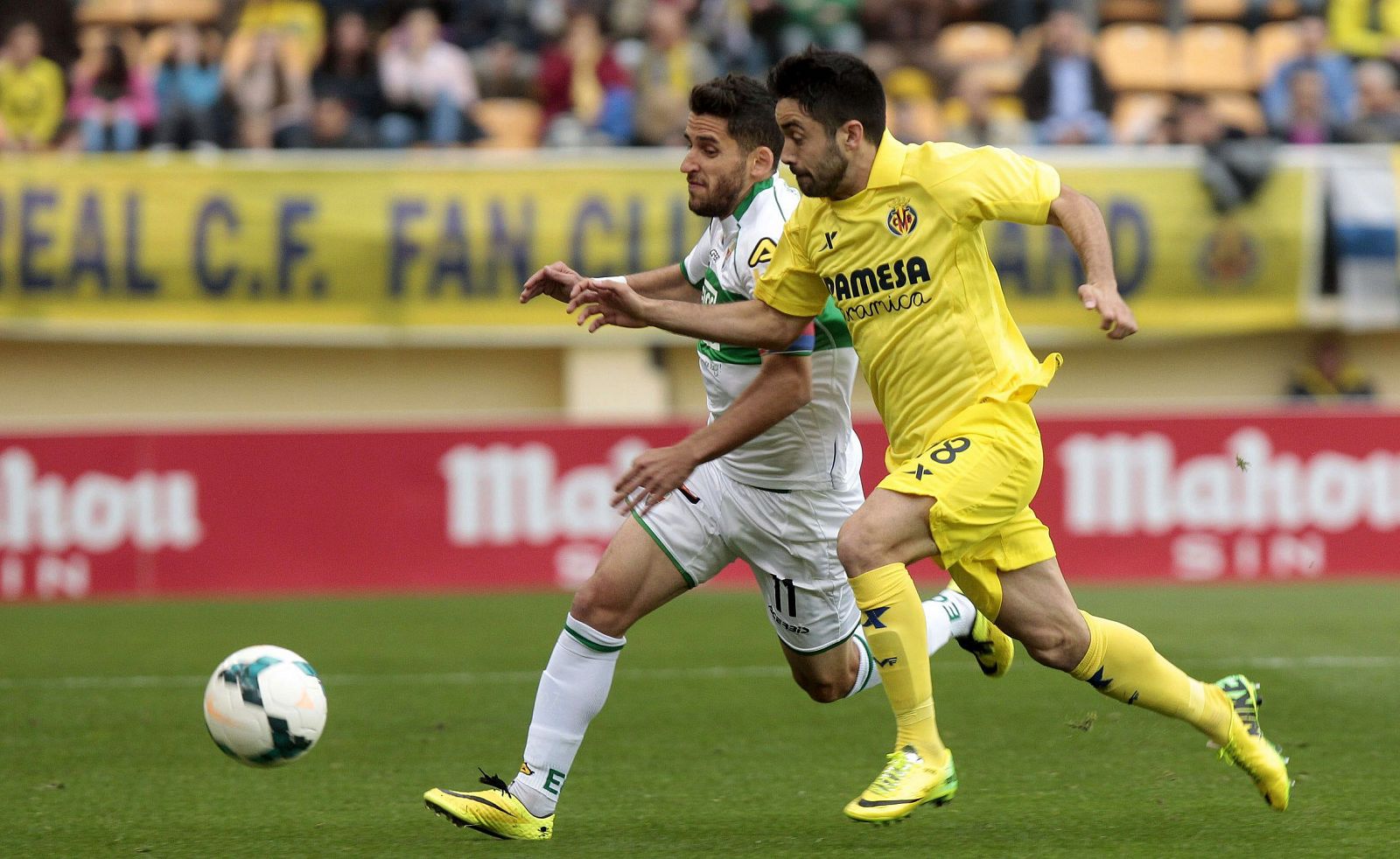 El delantero del Elche Ferrán Corominas (i) lucha un balón con el defensa del Villarreal Jaume Costa