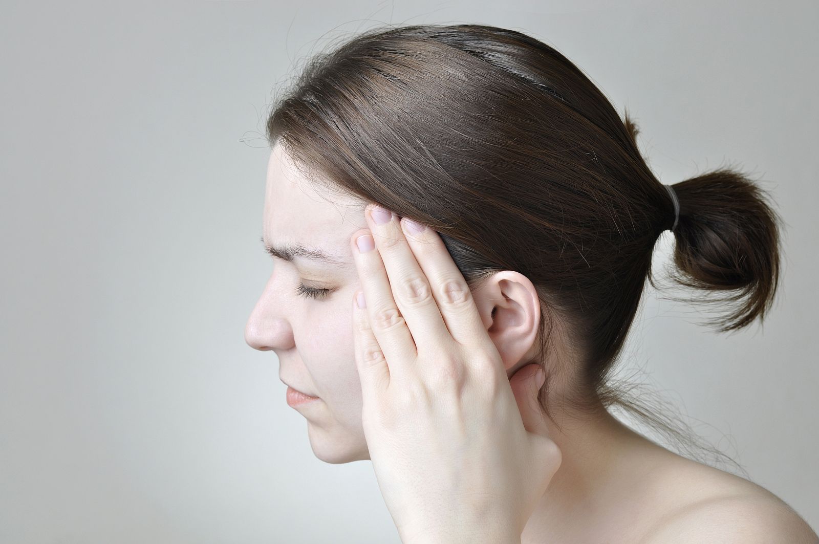 Mujer joven con un fuerte dolor de cabeza.