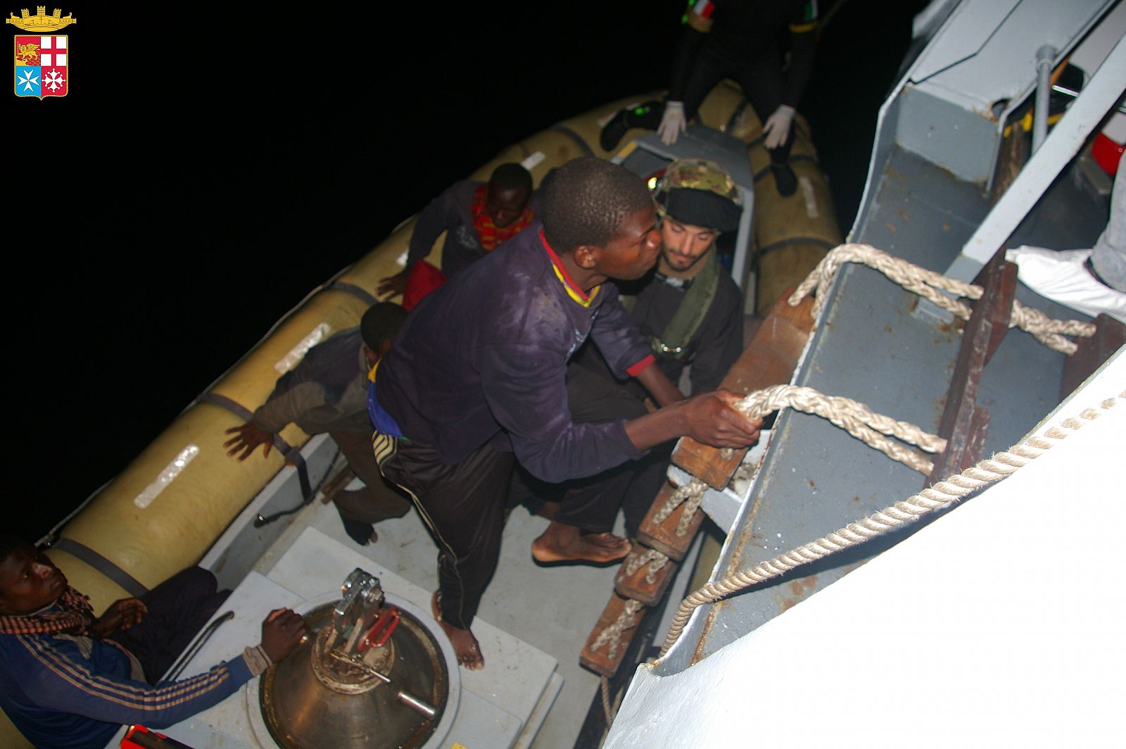 Imagen facilitada por la Marina italiana de los inmigrantes rescatados subiendo a bordo de uno de sus barcos