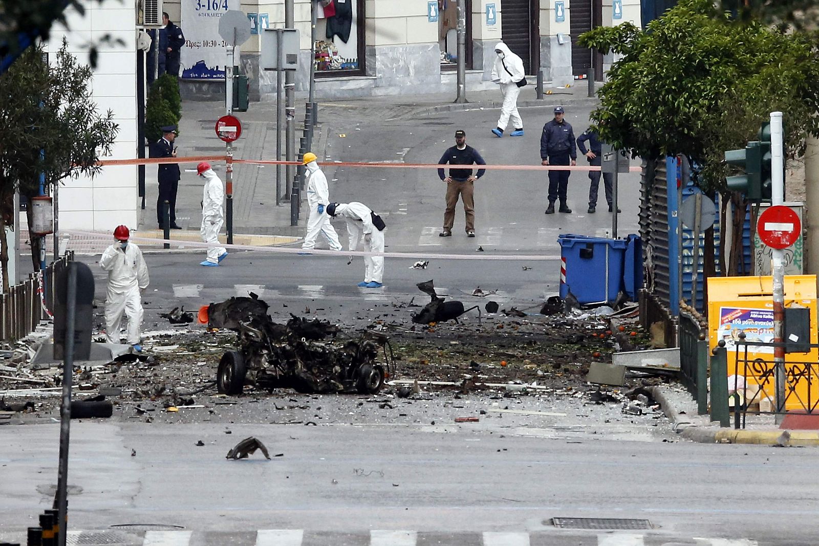 Expertos de la Policía buscan evidencias en el lugar de la explosión de un coche bomba, en Atenas