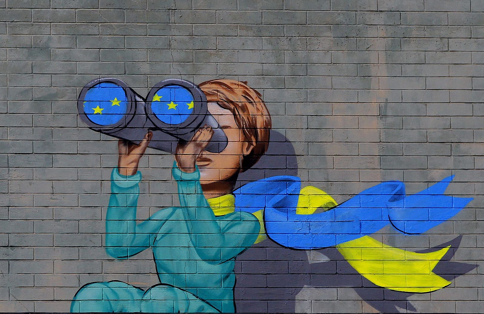 Un mural representa a una mujer ucraniana que mira hacia la UE con unos prismáticos en una pared en los alrededores de la Plaza Maidán en Kiev.