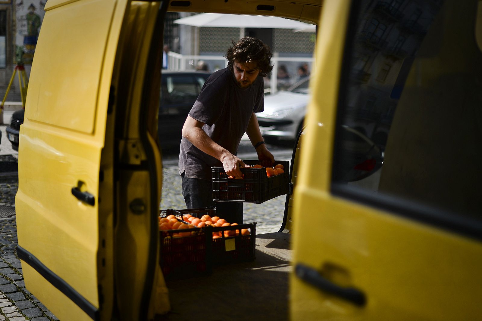 Un volantario de la cooperativa 'Fruta fea' carga fruta en una camioneta en Lisboa