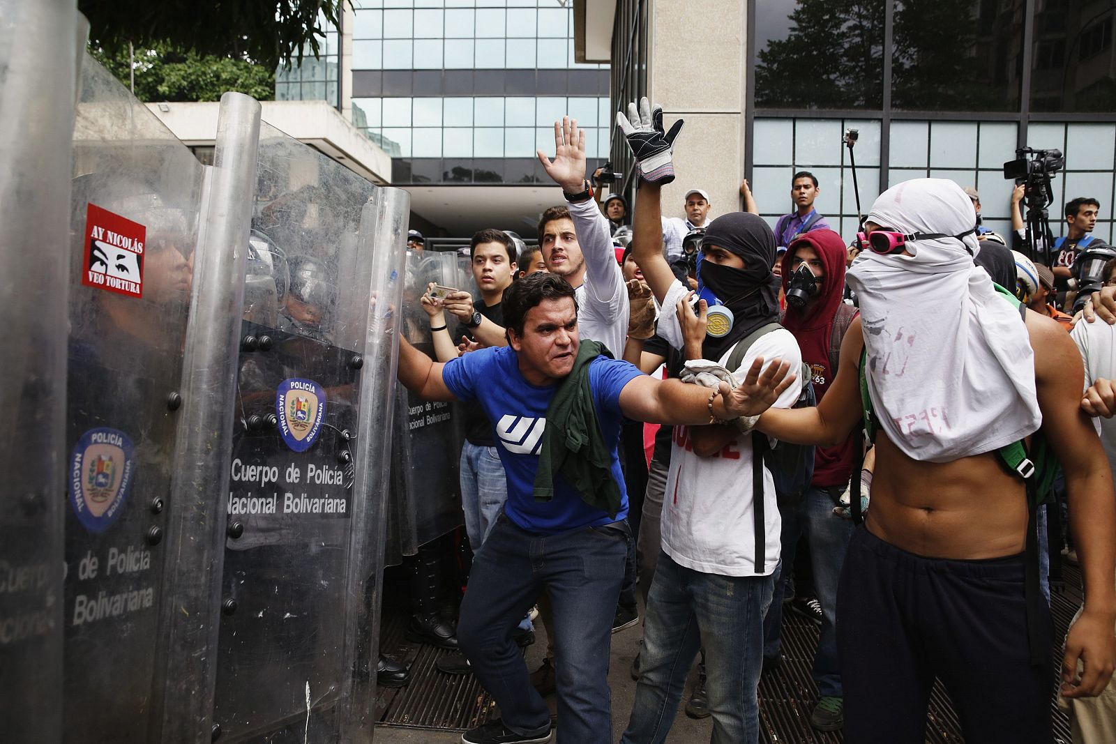 Un manifestante intenta evitar el enfrentamiento entre los antigubernamentales y la policía en Caracas.
