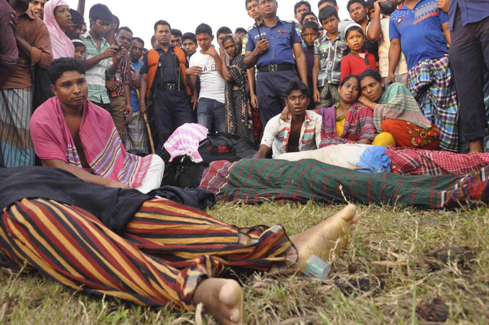 Familiares junto a los cuerpos de pasajeros fallecidos en el naufragio de un ferry en Bangladesh