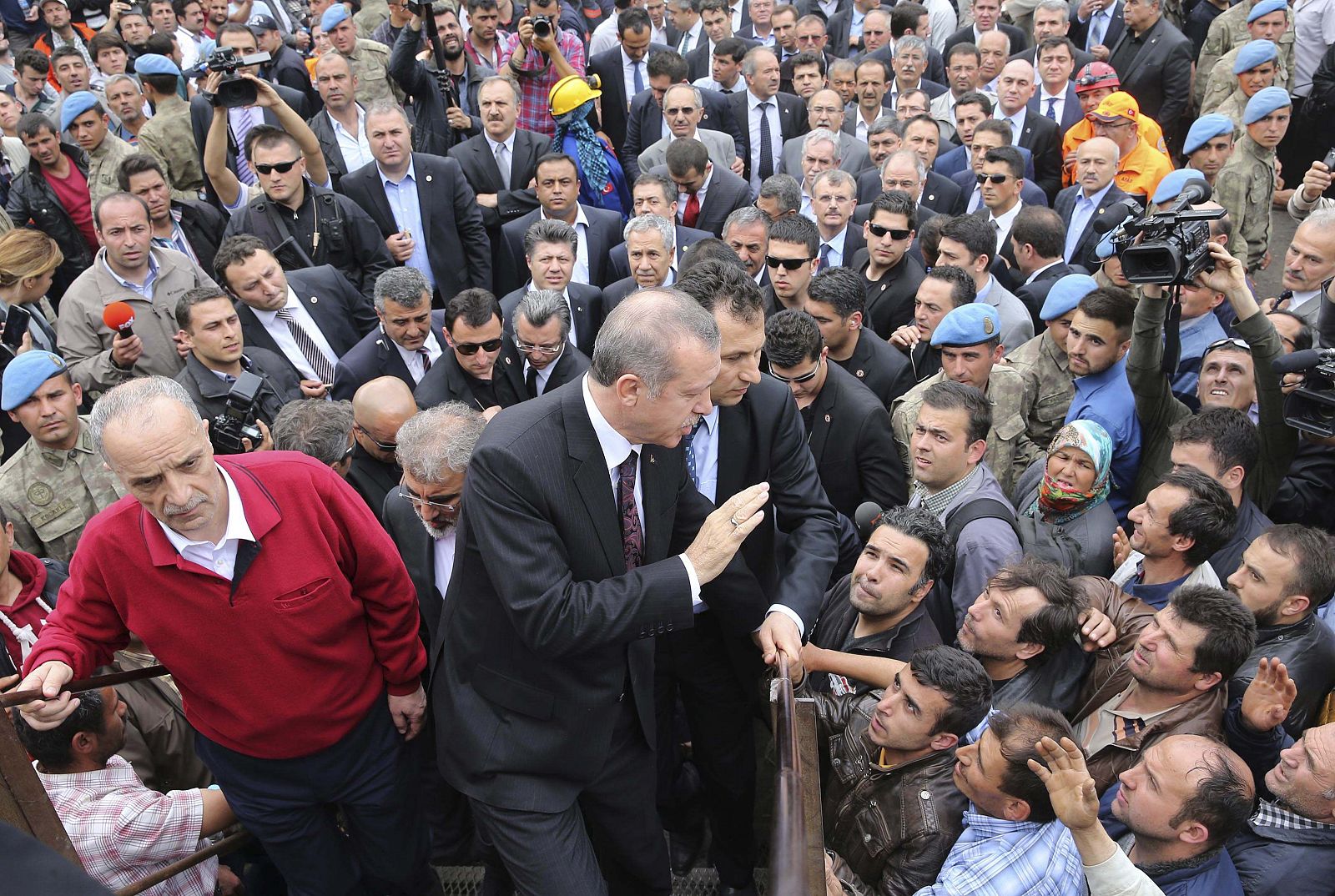 El primer ministro turco, Recept Tayyip Erdogan, pasea escoltado por sus guardaespaldas entre los vecinos del pueblo minero de Soma.