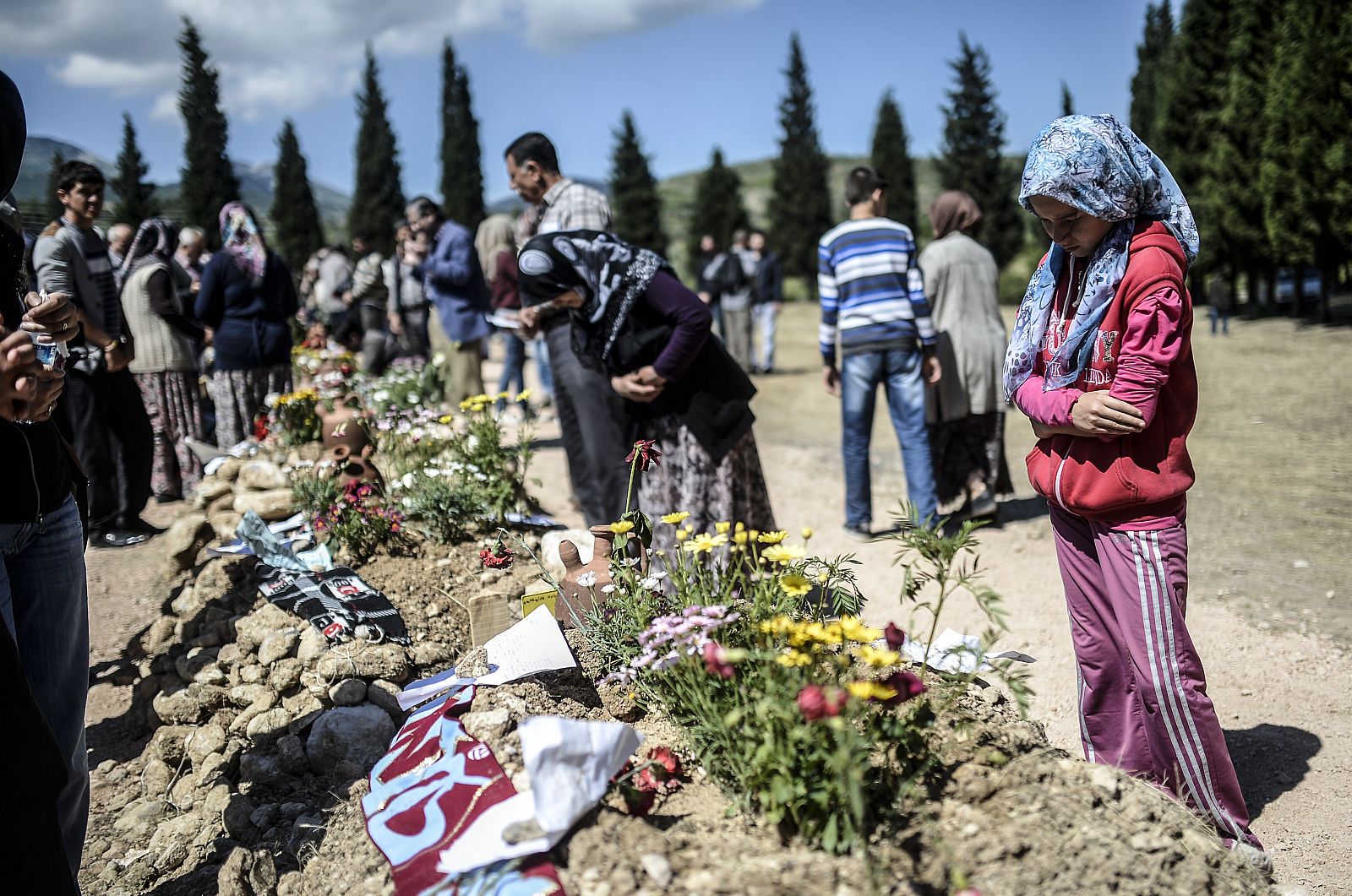 Varias personas depositan flores en memoria de los muertos en el desastre minero.