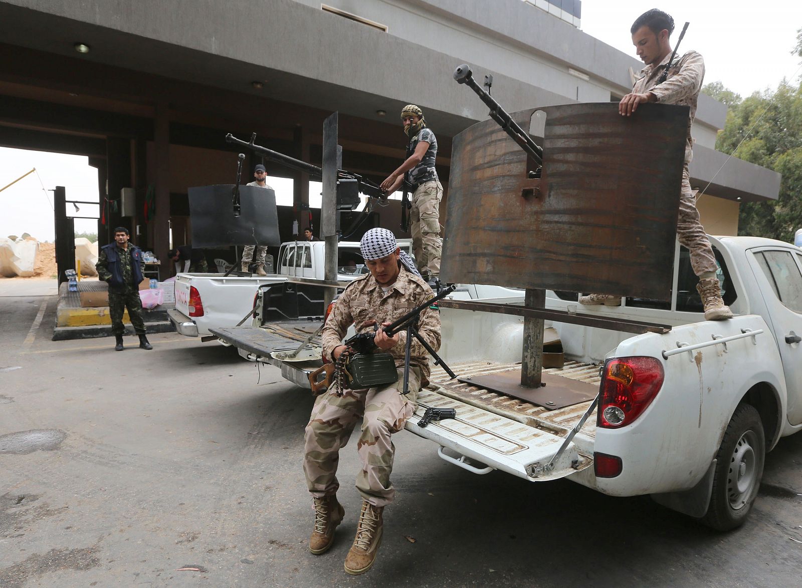 Ex combatientes rebeldes que ahora integran en el ejército libio revisan sus armas