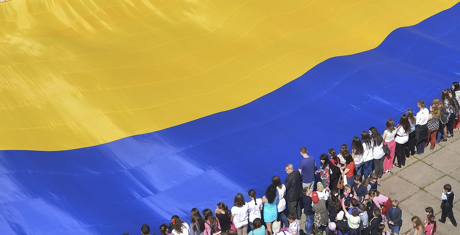Unos ciudadanos sostienen la que se considera la bandera de Ucrania más grande del mundo en la ciudad de Chernivtsi, en el suroeste de Ucrania