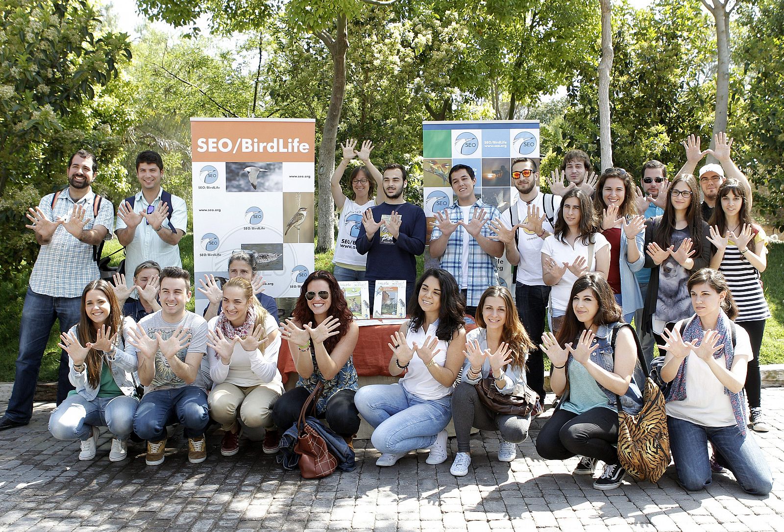 Estudiantes de veterinaria hacen el gesto de la mariposa por el Día Europeo de la Red Natura 2000 en el Bioparc de Valencia.
