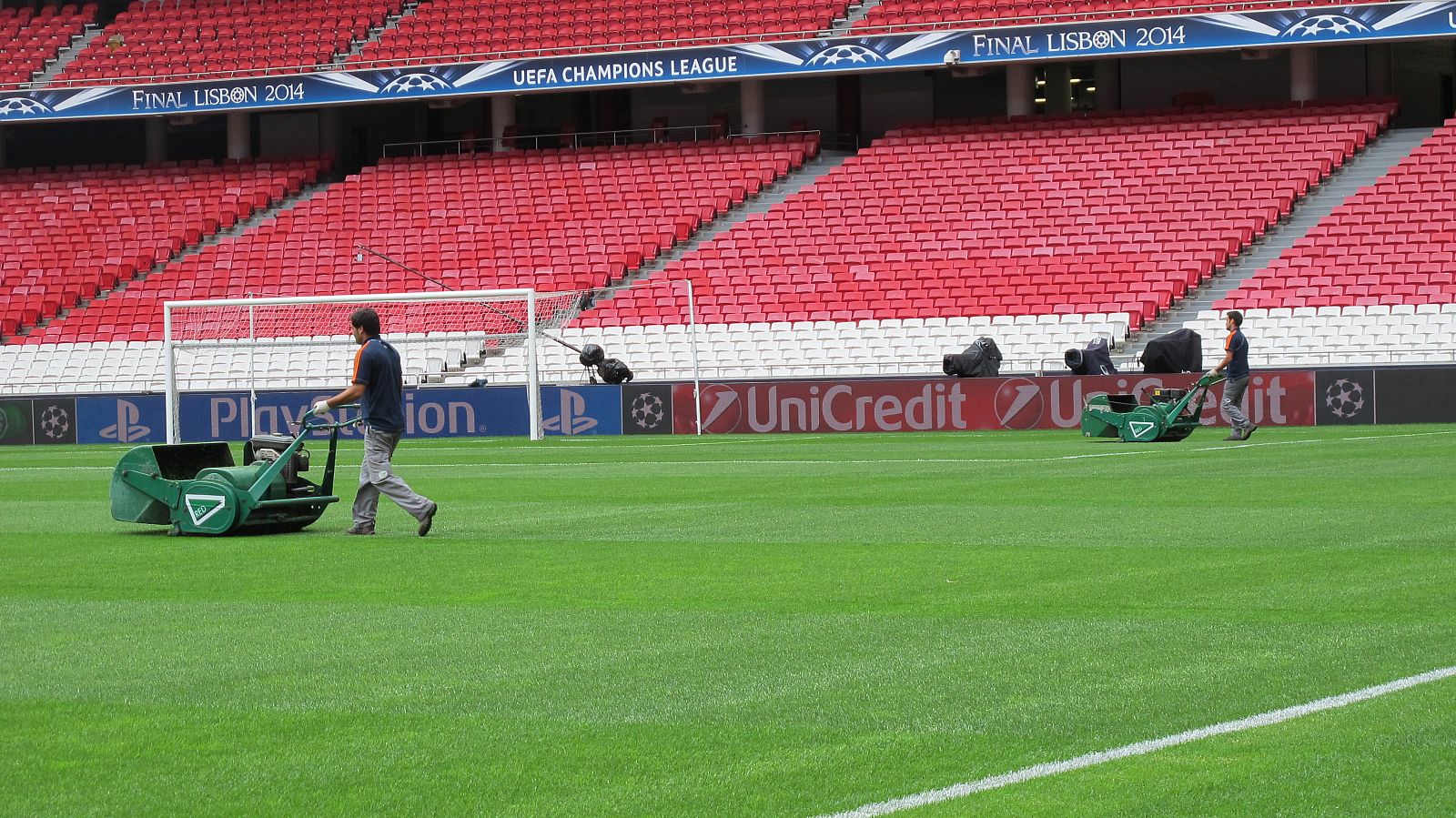 Dos operarios trabajan sobre el césped del Estádio da Luz.