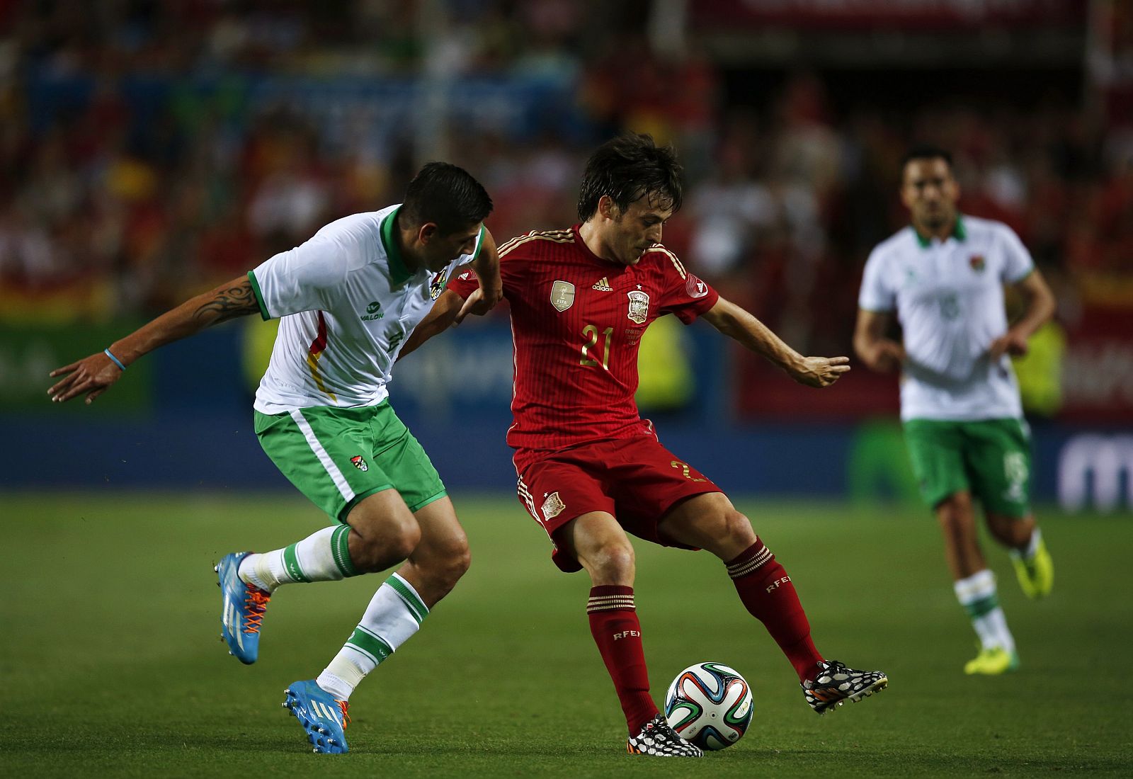 Spain's Silva is challenged by Bolivia's Eguino during their international friendly soccer match in Seville