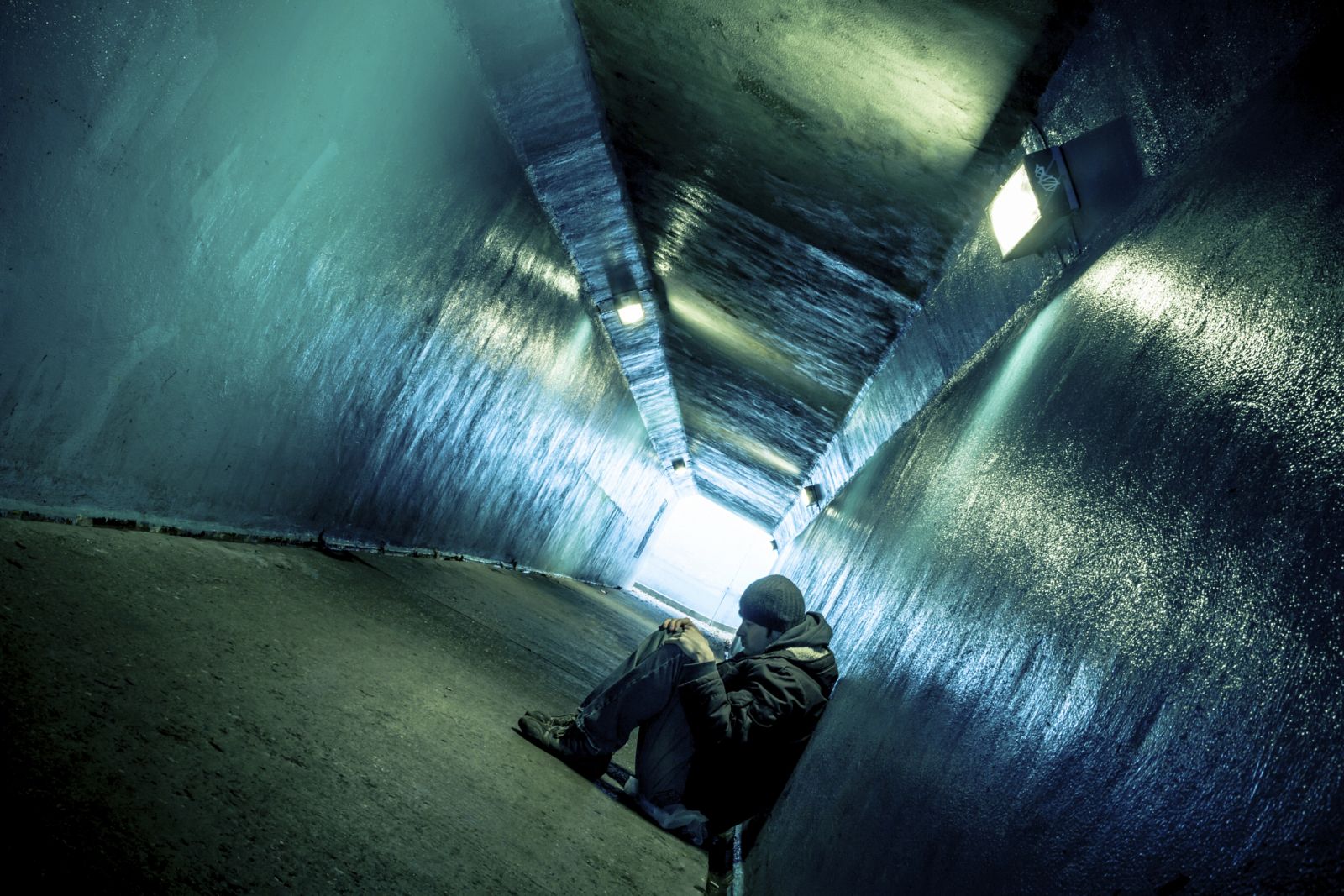 Un chico sentado en un túnel.