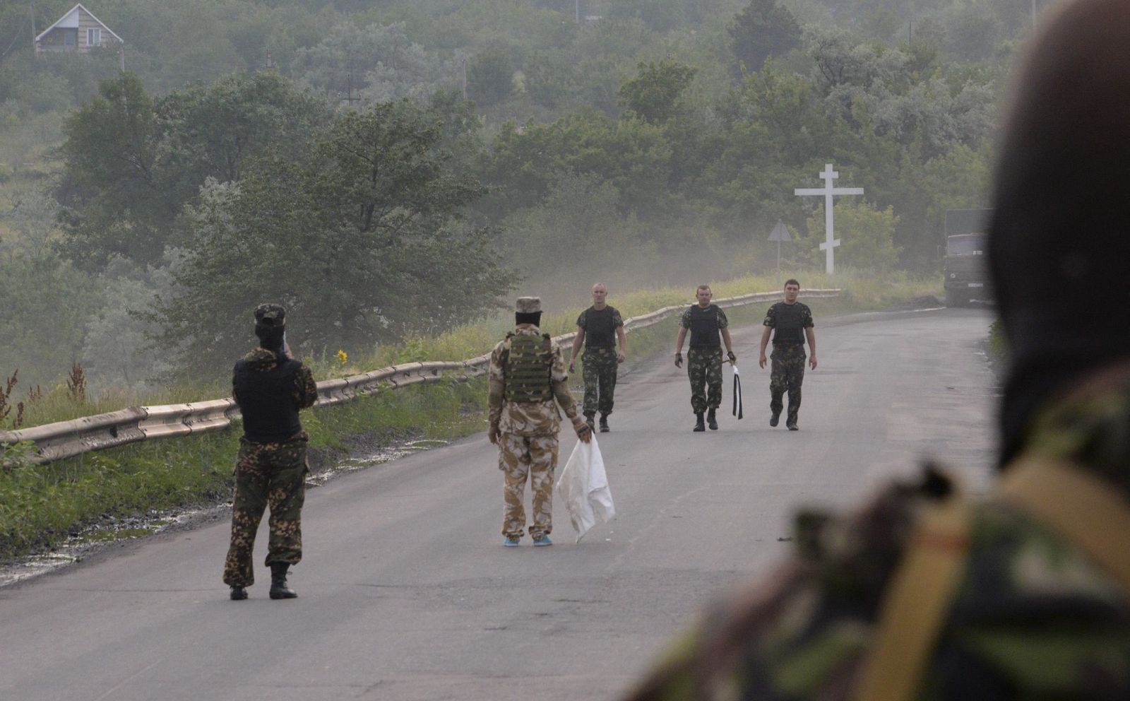 Milicianos prorrusos y soldados ucranianos durante un intercambio de cadáveres en Donetsk, Ucrania