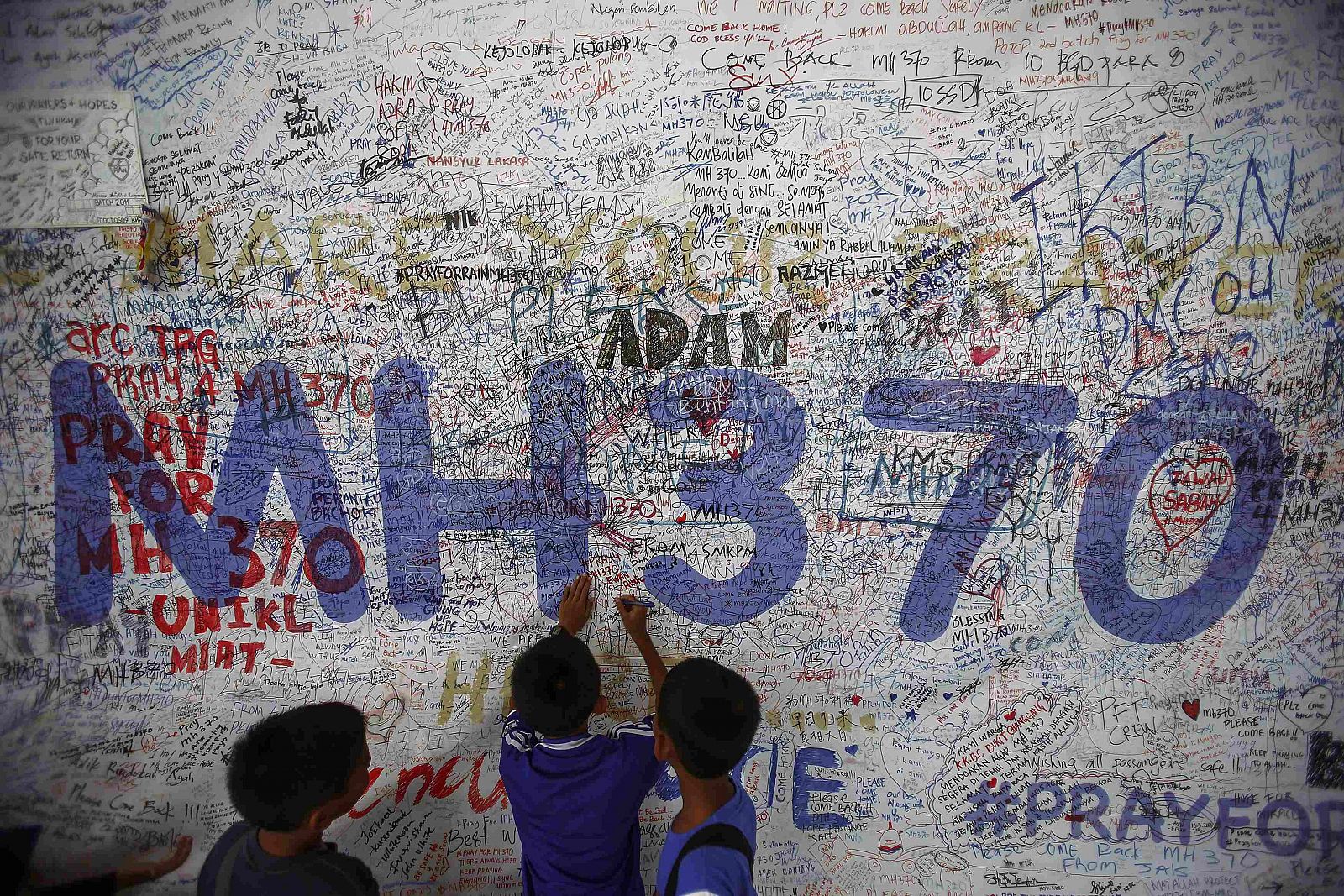 Niños escriben mensajes de esperanza para los pasajeros desaparecidos del vuelo MH370 en el aeropuerto de Kuala Lumpur.