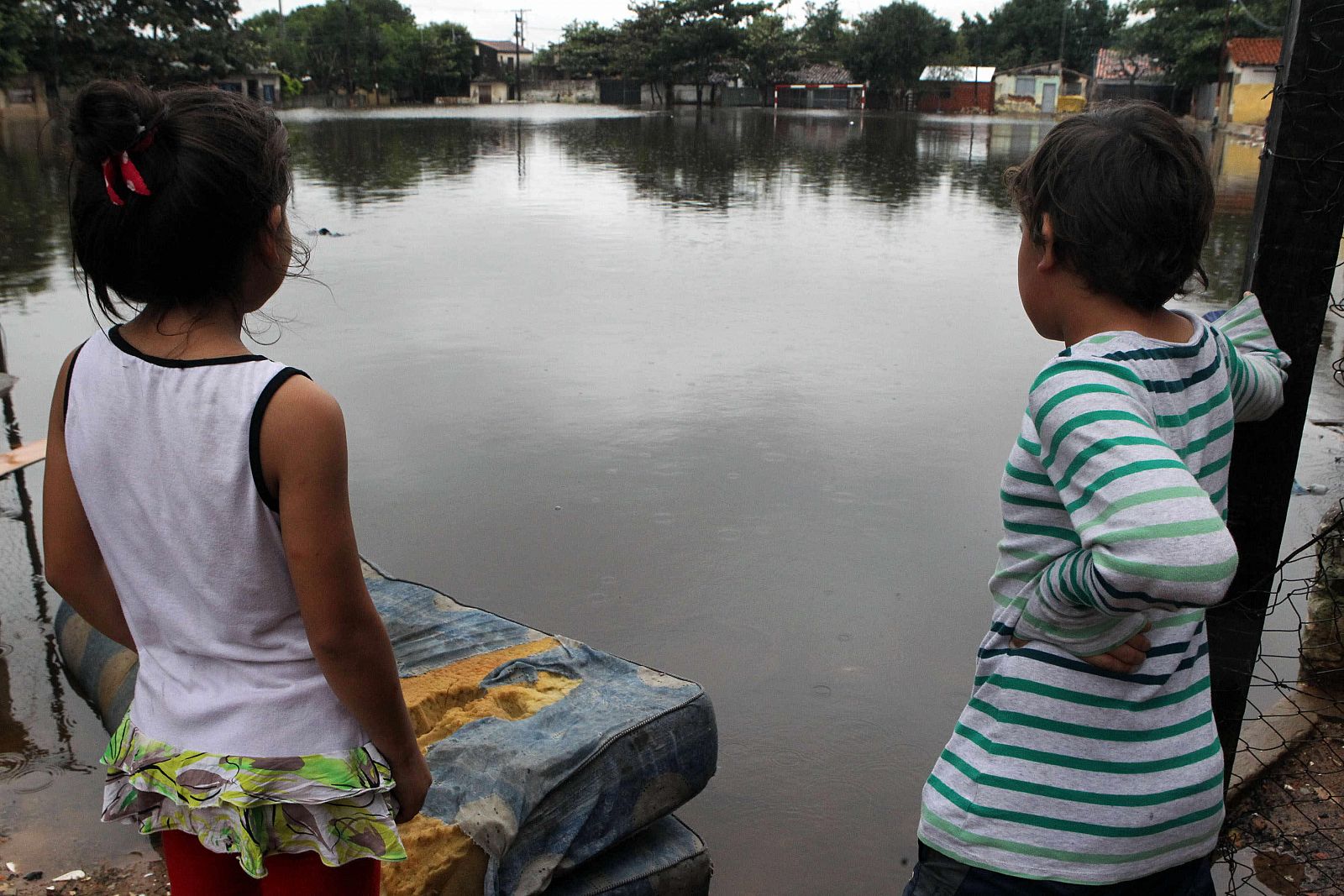 Dos niños observan las inhundacionesen un barrio de Asunción (Paraguay).