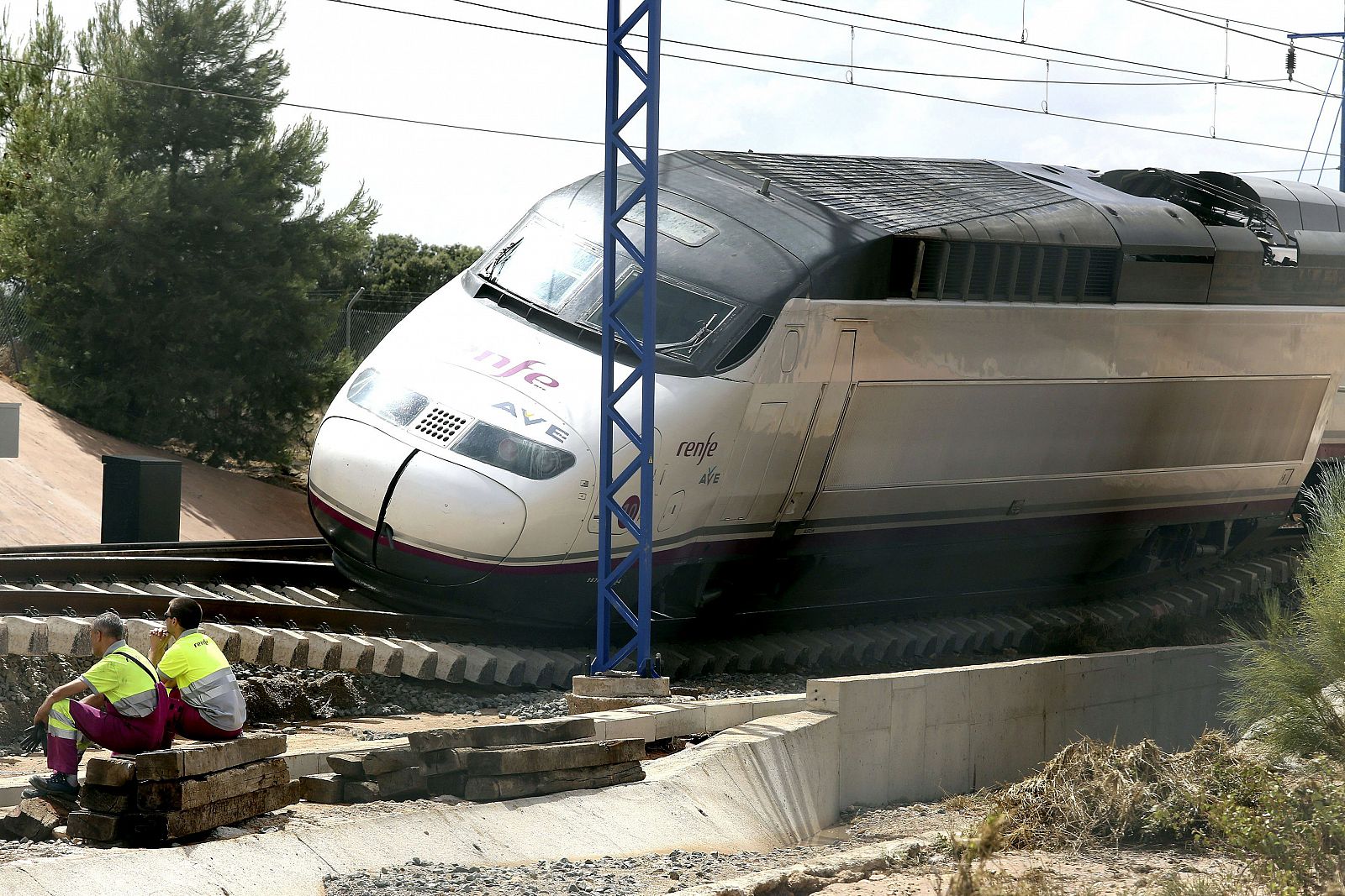 Operarios junto al tren que circulaba por la vía del AVE Madrid-Alicante.