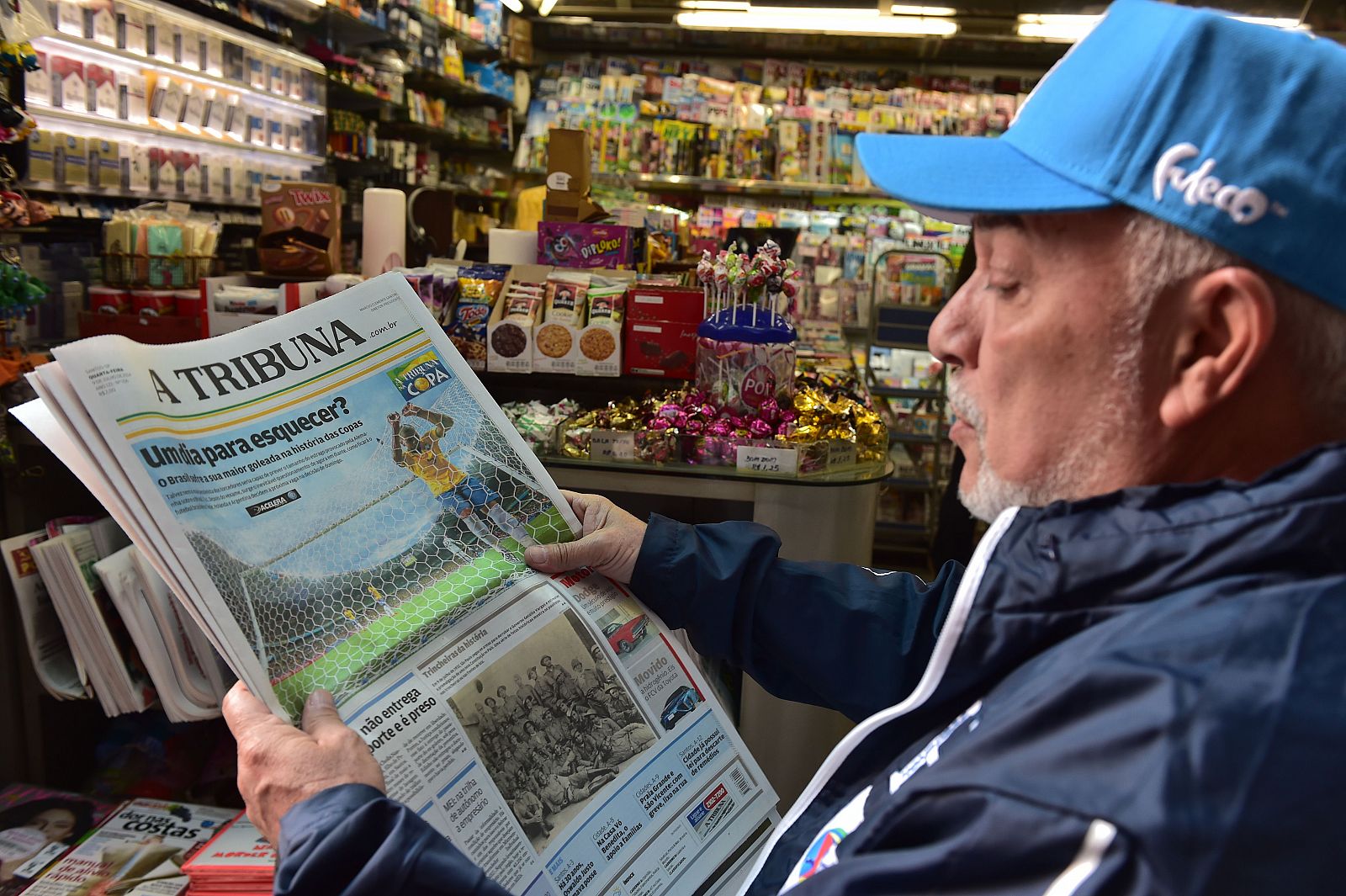 Un hombre revisa los titulares dela prensa deportiva tras la derrota de Brasil en el Mundial.